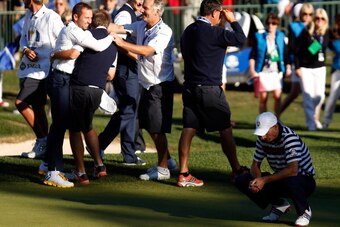 MEDINAH, IL - SEPTEMBER 30:  Jim Furyk of the USA (R) reacts to a missed par putt on the 18th green as Sergio Garcia and the European team celebrate during the Singles Matches for The 39th Ryder Cup at Medinah Country Club on September 30, 2012 in Medinah