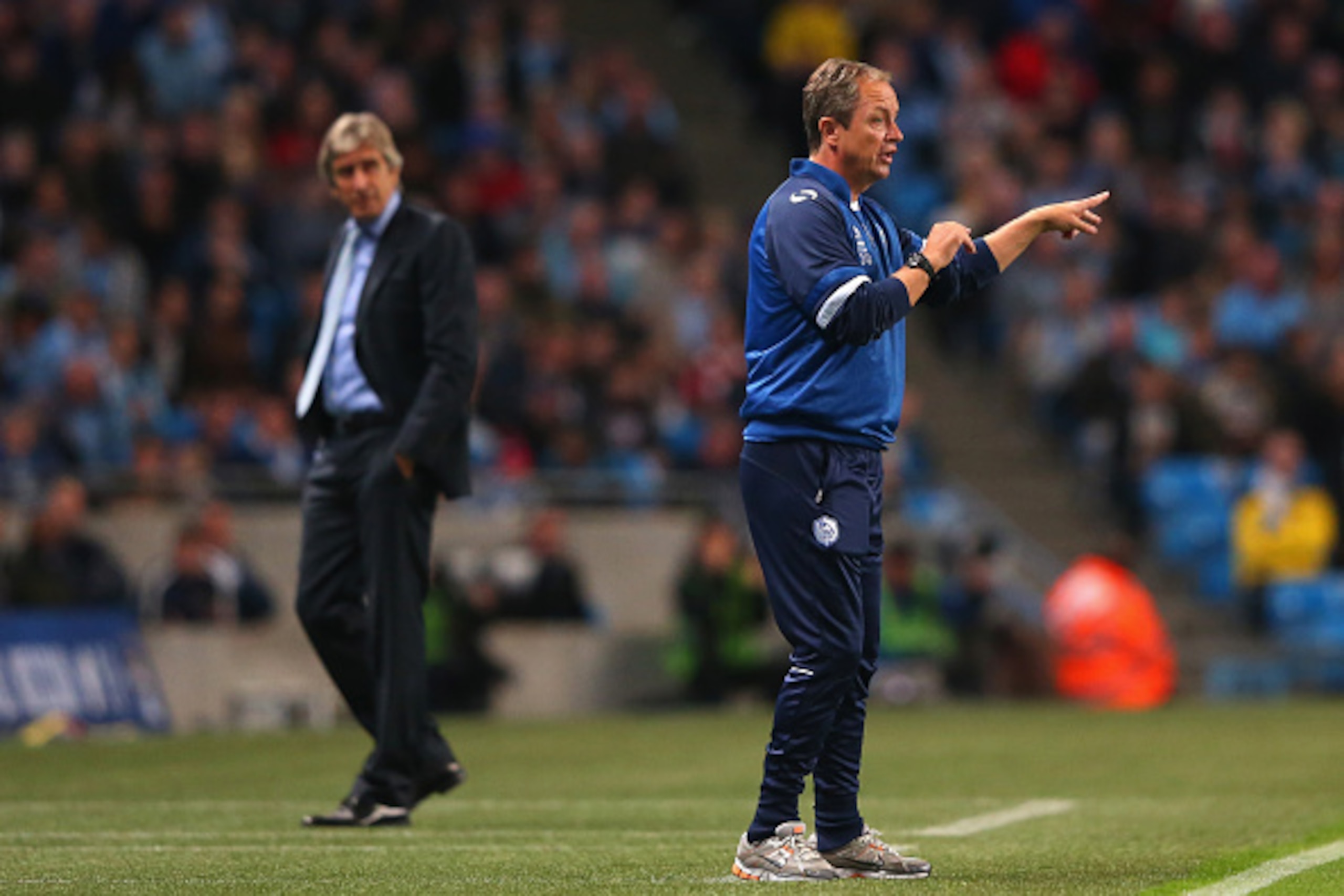 MANCHESTER, ENGLAND - SEPTEMBER 24:  Stuart Gray the manager of Sheffield Wednesday issues instructions to his players as Manuel Pellegrini the manager of Manchester City looks on during the Capital One Cup Third Round match between Manchester City and Sh