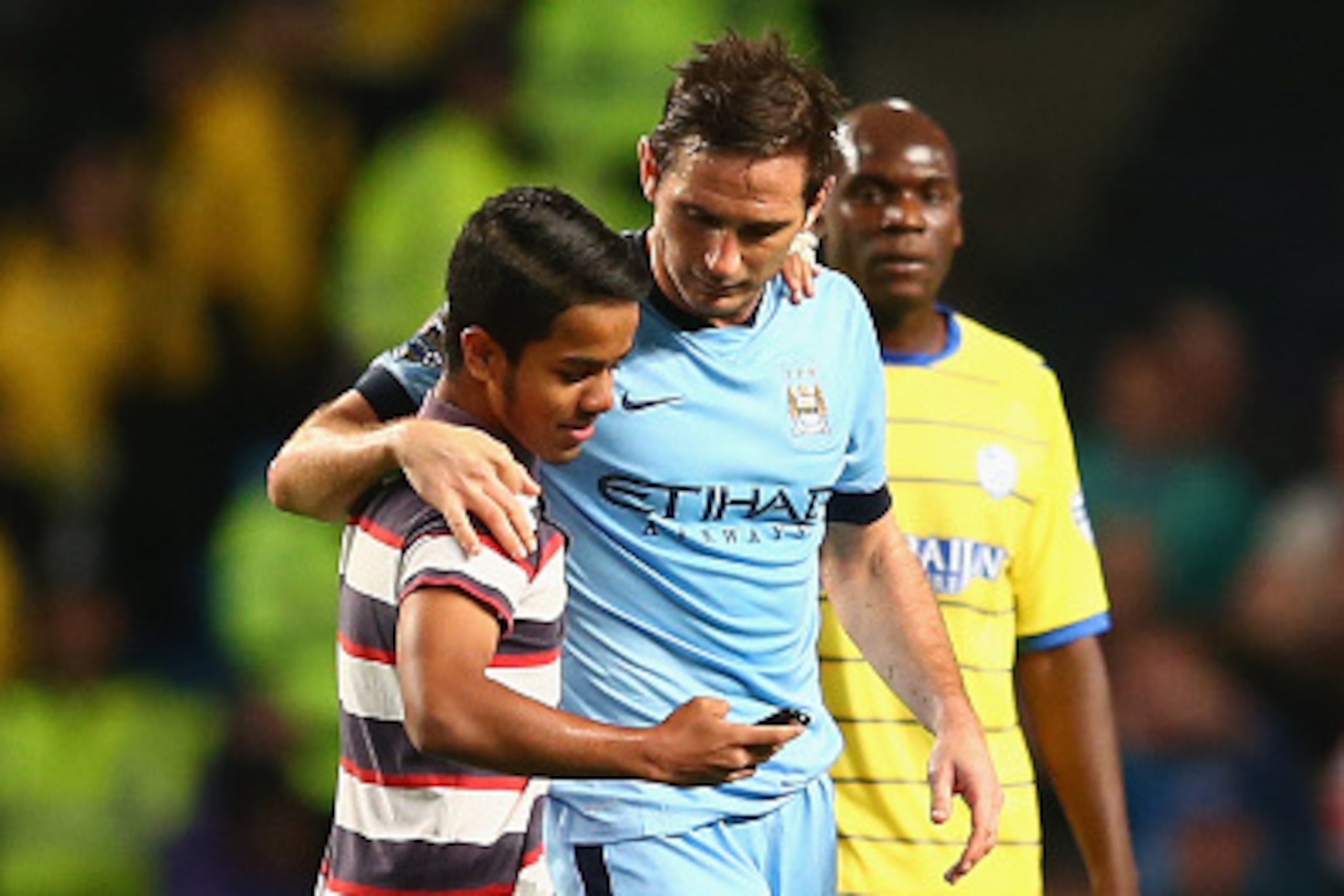 MANCHESTER, ENGLAND - SEPTEMBER 24: Frank Lampard of Manchester City speaks to a young fan who invaded the pitch to take a photo with him during the Capital One Cup Third Round match between Manchester City and Sheffield Wednesday at the Etihad Stadium on