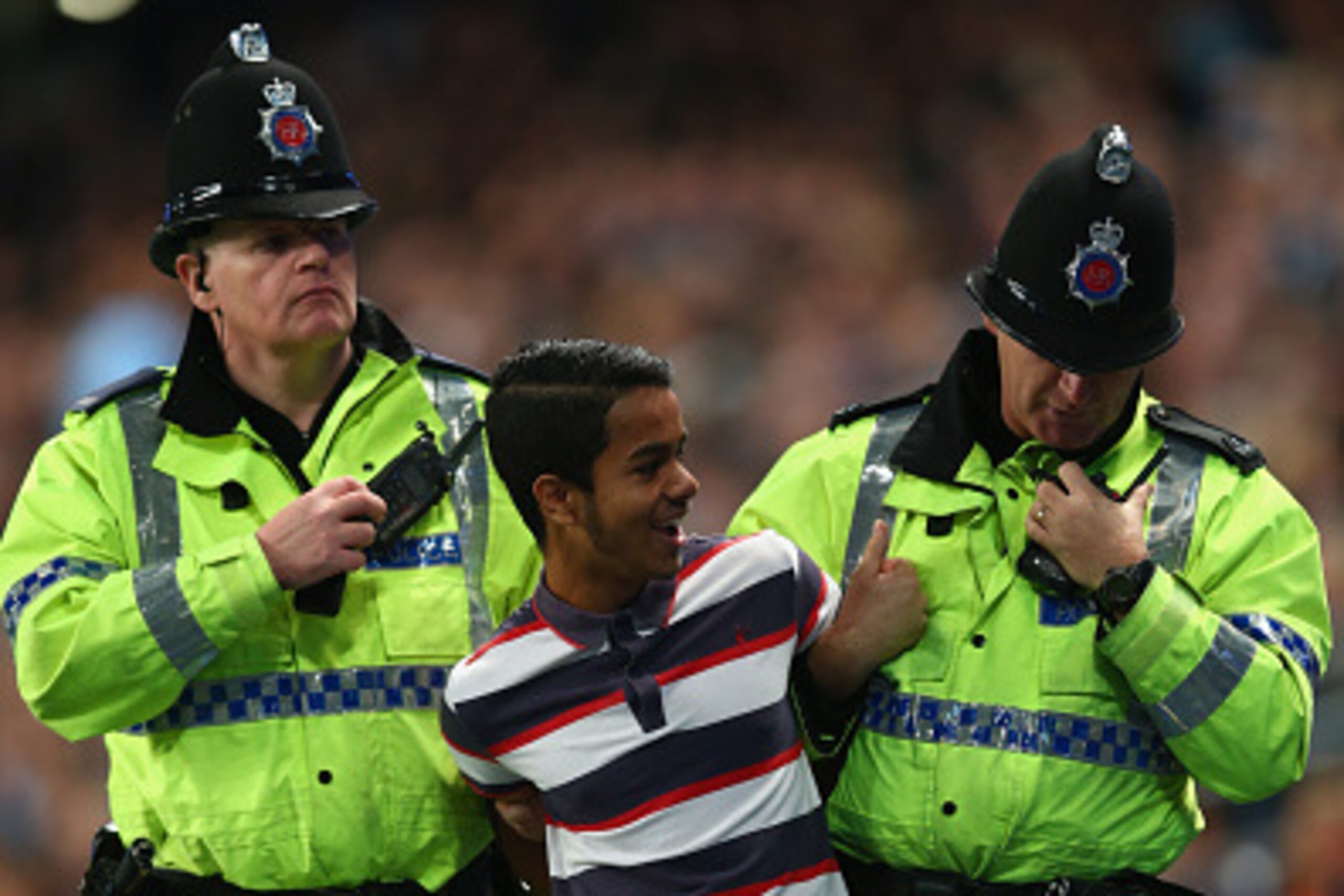 MANCHESTER, ENGLAND - SEPTEMBER 24: A supporter of Manchester City is ejected from the stadium after running onto the pitch to take a 'selfie' of Frank Lampard during the Capital One Cup Third Round match between Manchester City and Sheffield Wednesday at