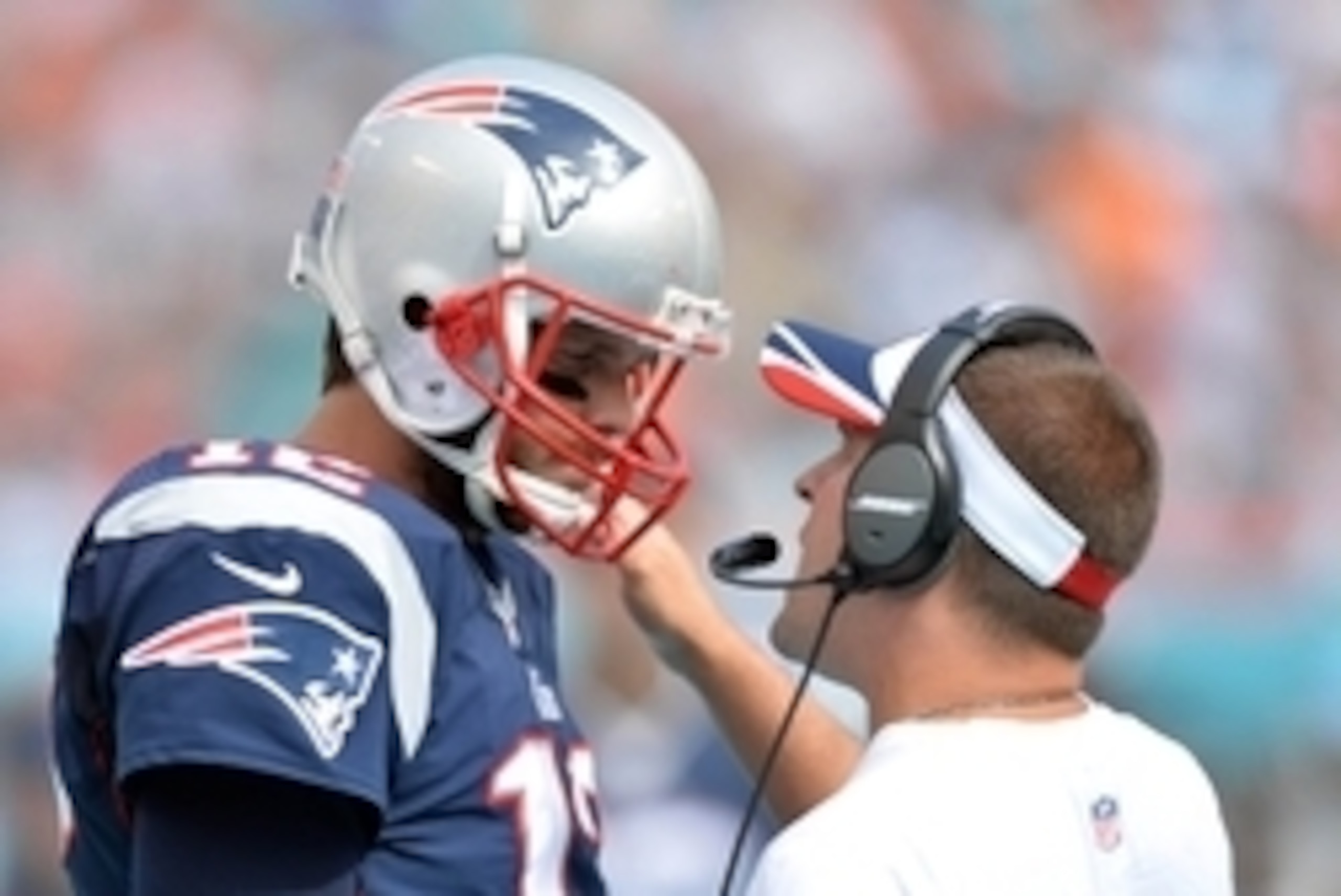Sep 7, 2014; Miami Gardens, FL, USA; New England Patriots quarterback Tom Brady (left) listens to offensive coordinator quarterbacks coach Josh McDaniels (right) during the second half against the Miami Dolphins at Sun Life Stadium. The Dolphins won 33-20