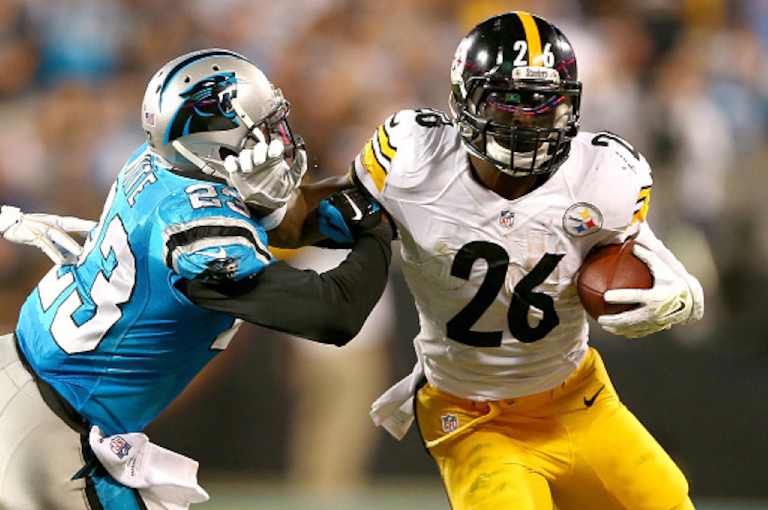 CHARLOTTE, NC - SEPTEMBER 21:  Melvin White #23 of the Carolina Panthers tries to stop Le'Veon Bell #26 of the Pittsburgh Steelers in the first half during the game at Bank of America Stadium on September 21, 2014 in Charlotte, North Carolina.  (Photo by 