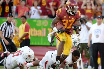 LOS ANGELES, CA - AUGUST 30:  Running back Javorius Allen #37 of the USC Trojans breaks the tackle of safety Charles Washington #28 of the Fresno State Bulldogs to score a touchdown for a 38-13 lead during the third quarter at Los Angeles Memorial Coliseu