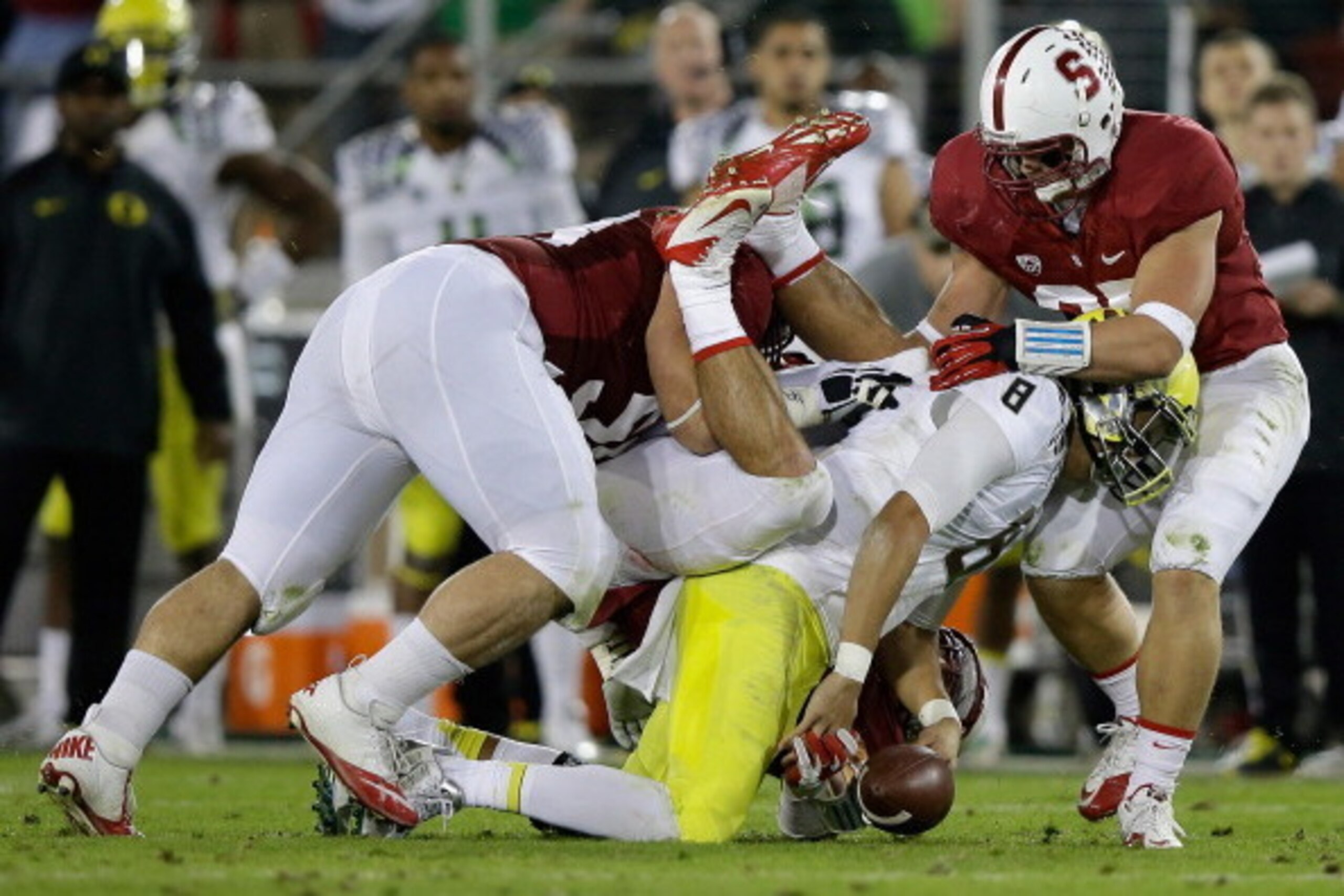 PALO ALTO, CA - NOVEMBER 07:  Marcus Mariota #8 of the Oregon Ducks fumbles the ball as he is tackled by David Parry #58, A.J. Tarpley #17 and Jarek Lancaster #35 of the Stanford Cardinal at Stanford Stadium on November 7, 2013 in Palo Alto, California.  