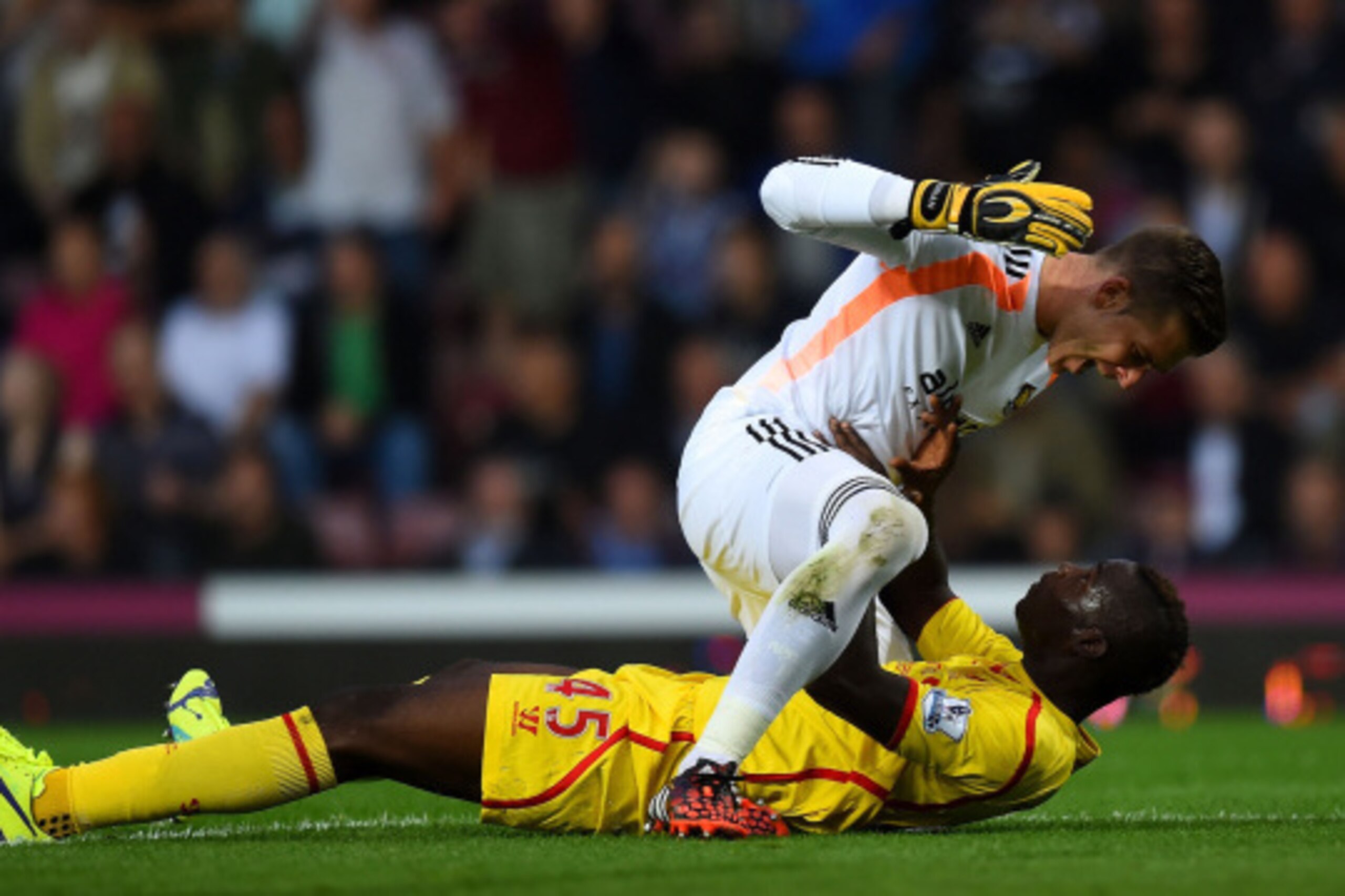 LONDON, ENGLAND - SEPTEMBER 20:  Mario Balotelli of Liverpool and Adrian of West Ham clash following a heavy tackle by Balotelli on Adrian during the Barclays Premier League match between West Ham United and Liverpool at Boleyn Ground on September 20, 201