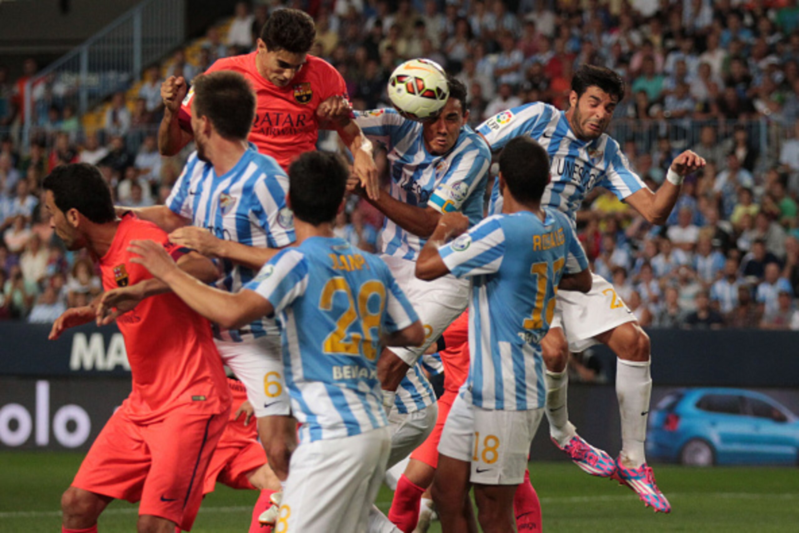 MALAGA, SPAIN - SEPTEMBER 24:  Marc Bartra of F.C. Barcelona (top L), has a head shot on goal under pressure from Weligton Robson of Malaga CF (R), during the La Liga match between Malaga CF and FC Barcelona at La Rosaleda studium on September 24, 2014 in