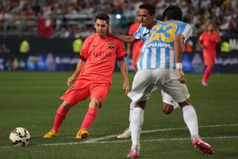 MALAGA, SPAIN - SEPTEMBER 24:  Lionel Messi of F.C. Barcelona is tackled by Weligton Robson of Malaga CF during the La Liga match between Malaga CF and FC Barcelona at La Rosaleda studium on September 24, 2014 in Malaga, Spain. (Photo by Sergio Camacho/Ge