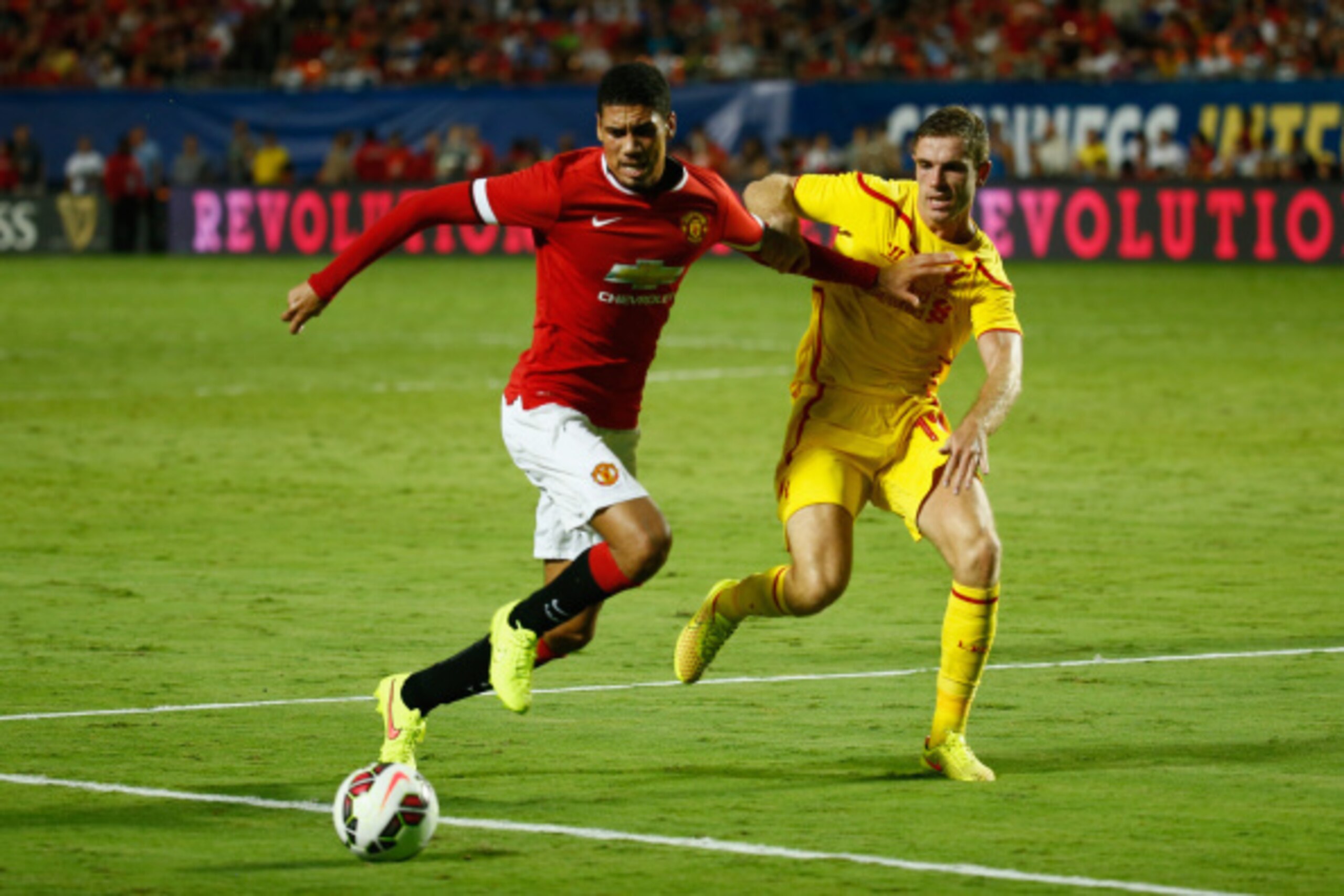 MIAMI GARDENS, FL - AUGUST 04:  (L) Chris Smalling #12 of Manchester United is challenged by (R) Jordan Henderson #14 of Liverpool in the Guinness International Champions Cup 2014 Final at Sun Life Stadium on August 4, 2014 in Miami Gardens, Florida.  (Ph