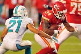 Sep 21, 2014; Miami Gardens, FL, USA; Miami Dolphins cornerback Brent Grimes (21) hits Kansas City Chiefs running back Knile Davis (34) causing a fumble at Sun Life Stadium. The Chiefs defeated the Dolphins 34-15.  Mandatory Credit: Brad Barr-USA TODAY Sp