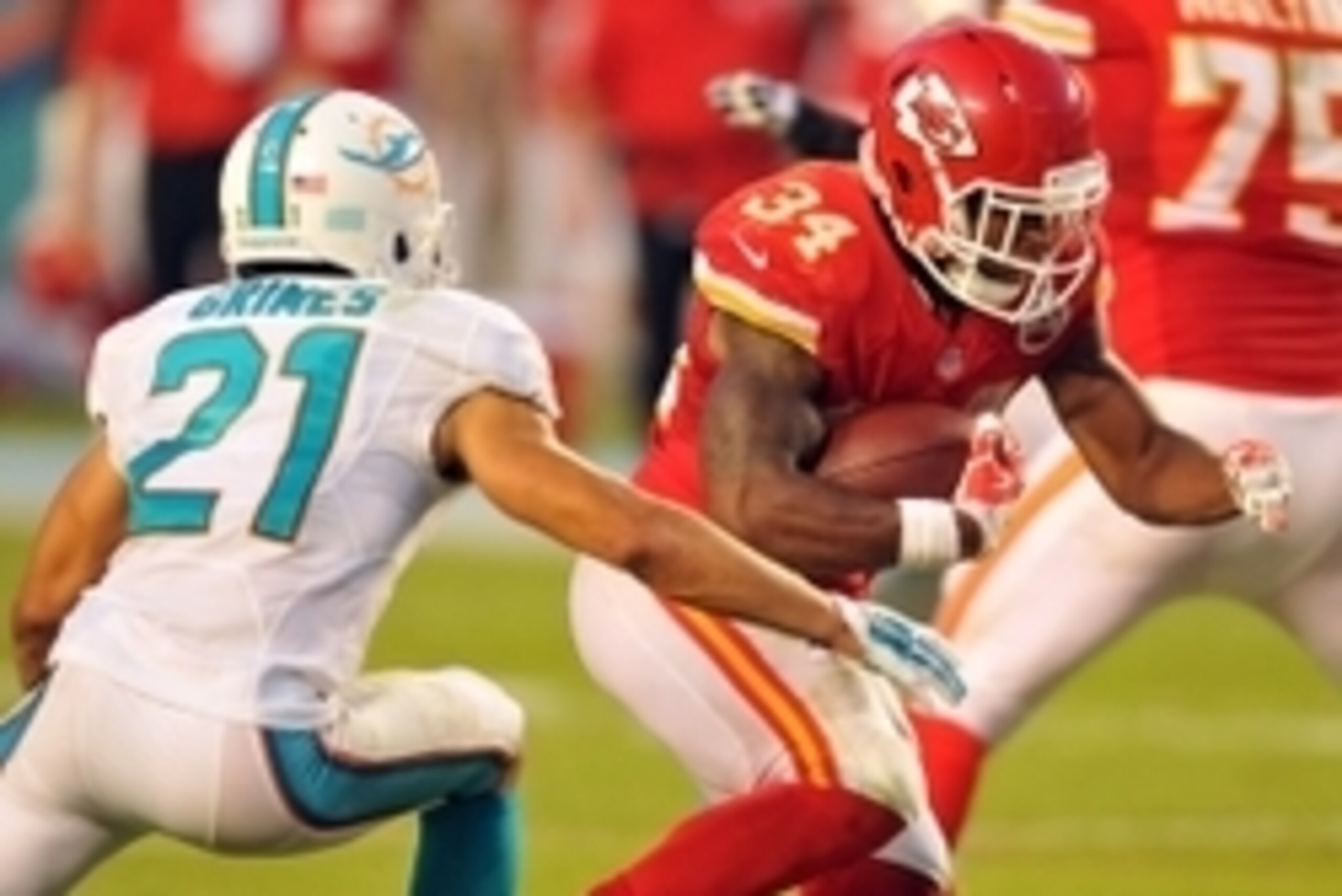 Sep 21, 2014; Miami Gardens, FL, USA; Miami Dolphins cornerback Brent Grimes (21) hits Kansas City Chiefs running back Knile Davis (34) causing a fumble at Sun Life Stadium. The Chiefs defeated the Dolphins 34-15.  Mandatory Credit: Brad Barr-USA TODAY Sp
