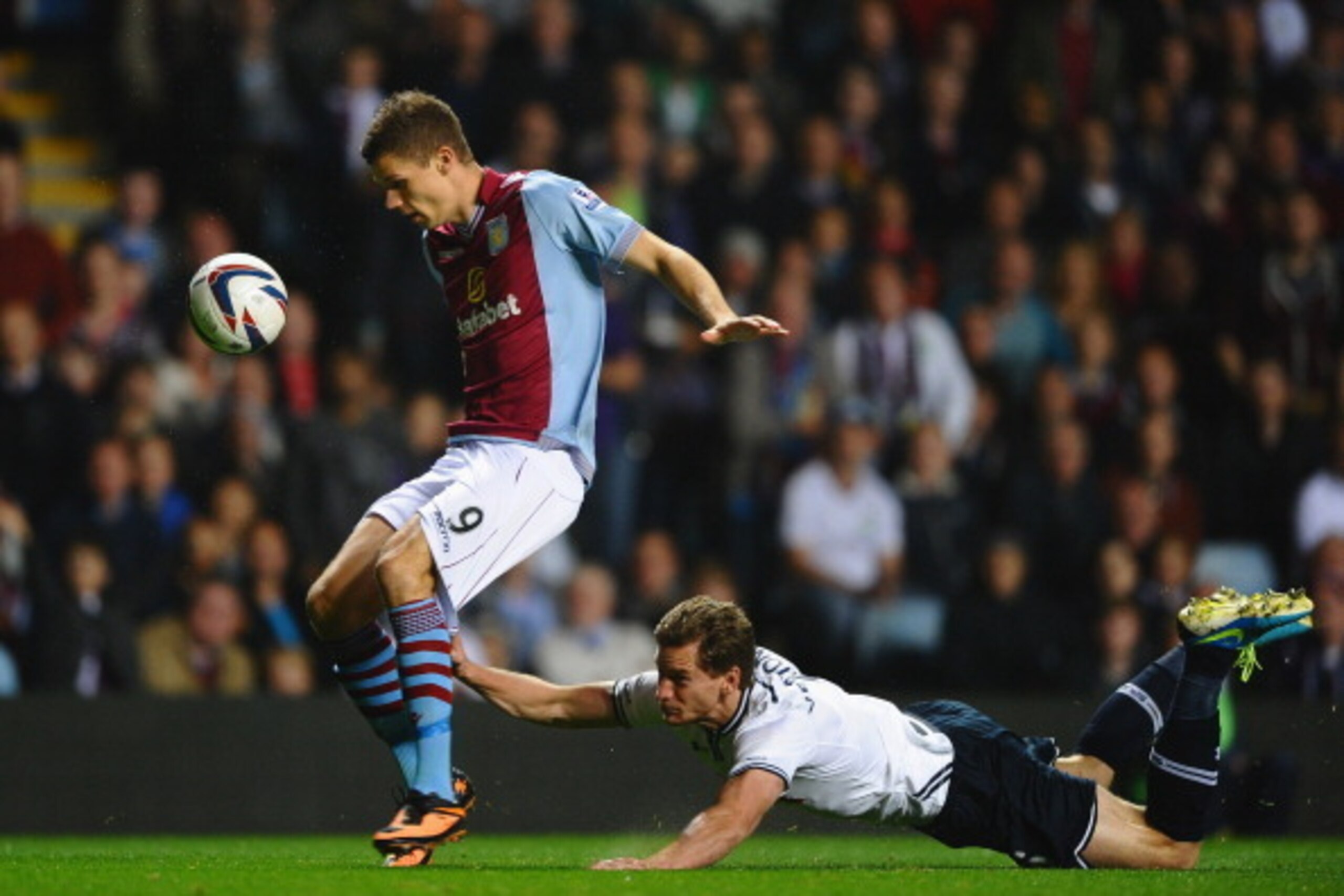 BIRMINGHAM, ENGLAND - SEPTEMBER 24:  Jan Vertonghen of Tottenham Hotspur hangs on to the shorts of Nicklas Helenius of Aston Villa during the Capital One Cup third round match between Aston Villa and Tottenham Hotspur at Villa Park on September 24, 2013 i