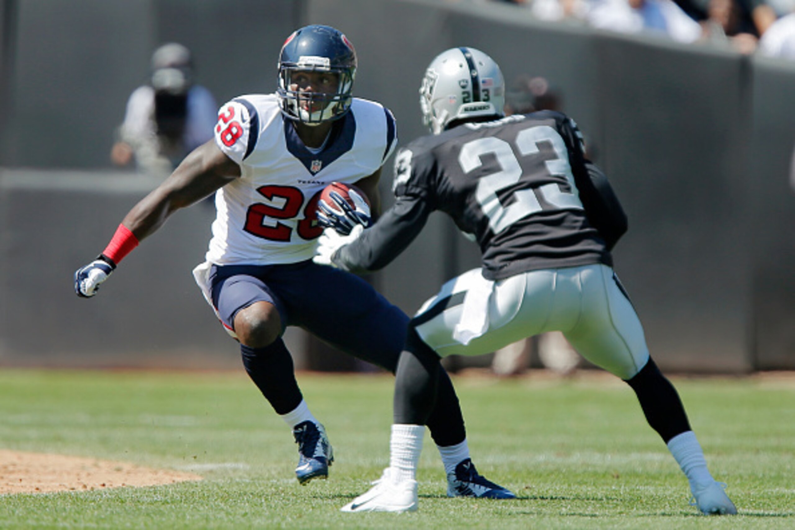 OAKLAND, CA - SEPTEMBER 14:  Running back Alfred Blue #28 of the Houston Texans makes a cut against cornerback Tarell Brown #23 of the Oakland Raiders on September 14, 2014 at O.co Coliseum in Oakland, California.  The Texans won 30-14.  (Photo by Brian B