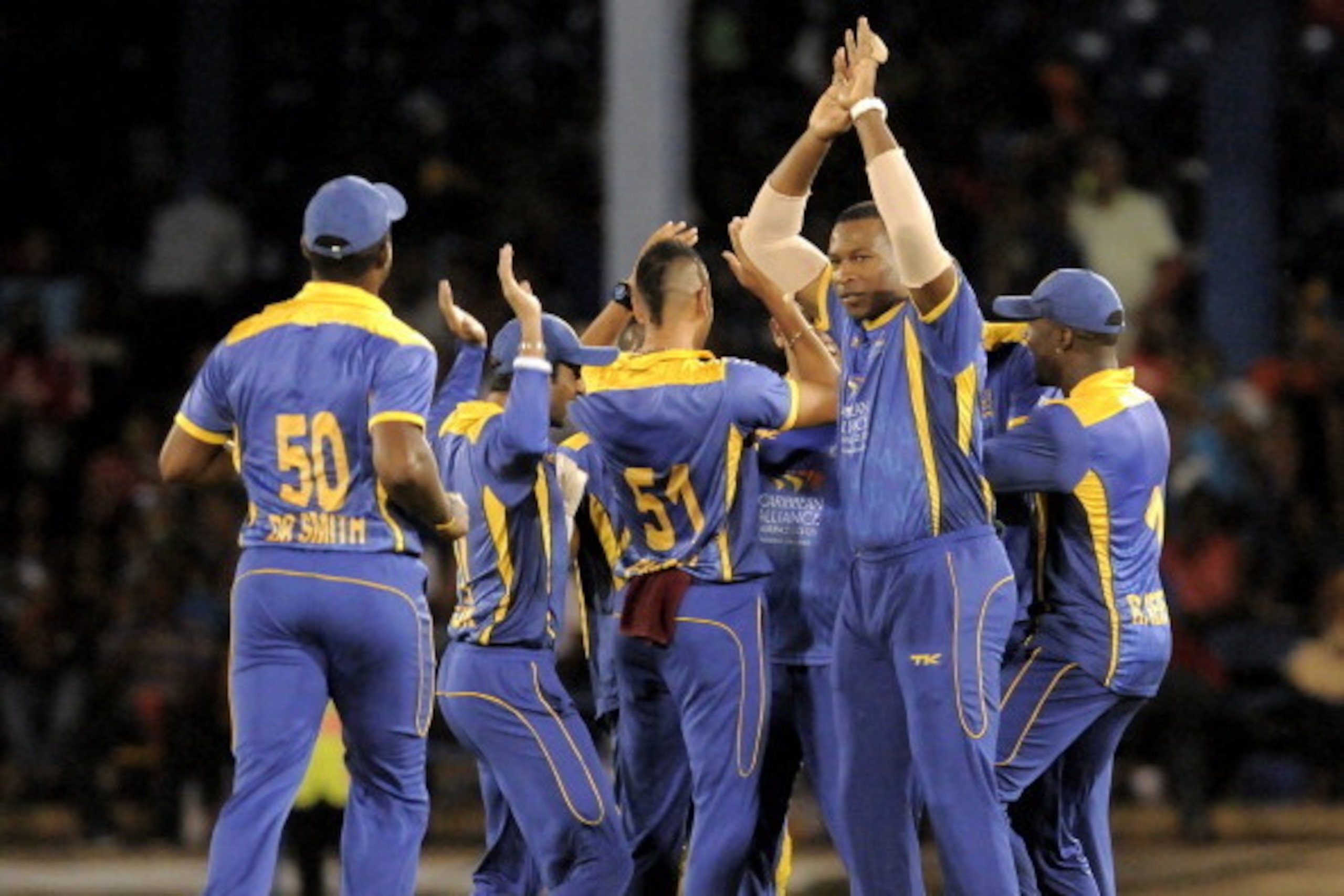 PORT OF SPAIN, TRINIDAD AND TOBAGO - AUGUST 23:  Kieron Pollard (R) of Barbados Tridents celebrates Jamaica Tallawahs Chris Gayle out during the Second Semi Final of the Caribbean Premier League between Barbados Tridents v Jamaica Tallawahs at Queens Park
