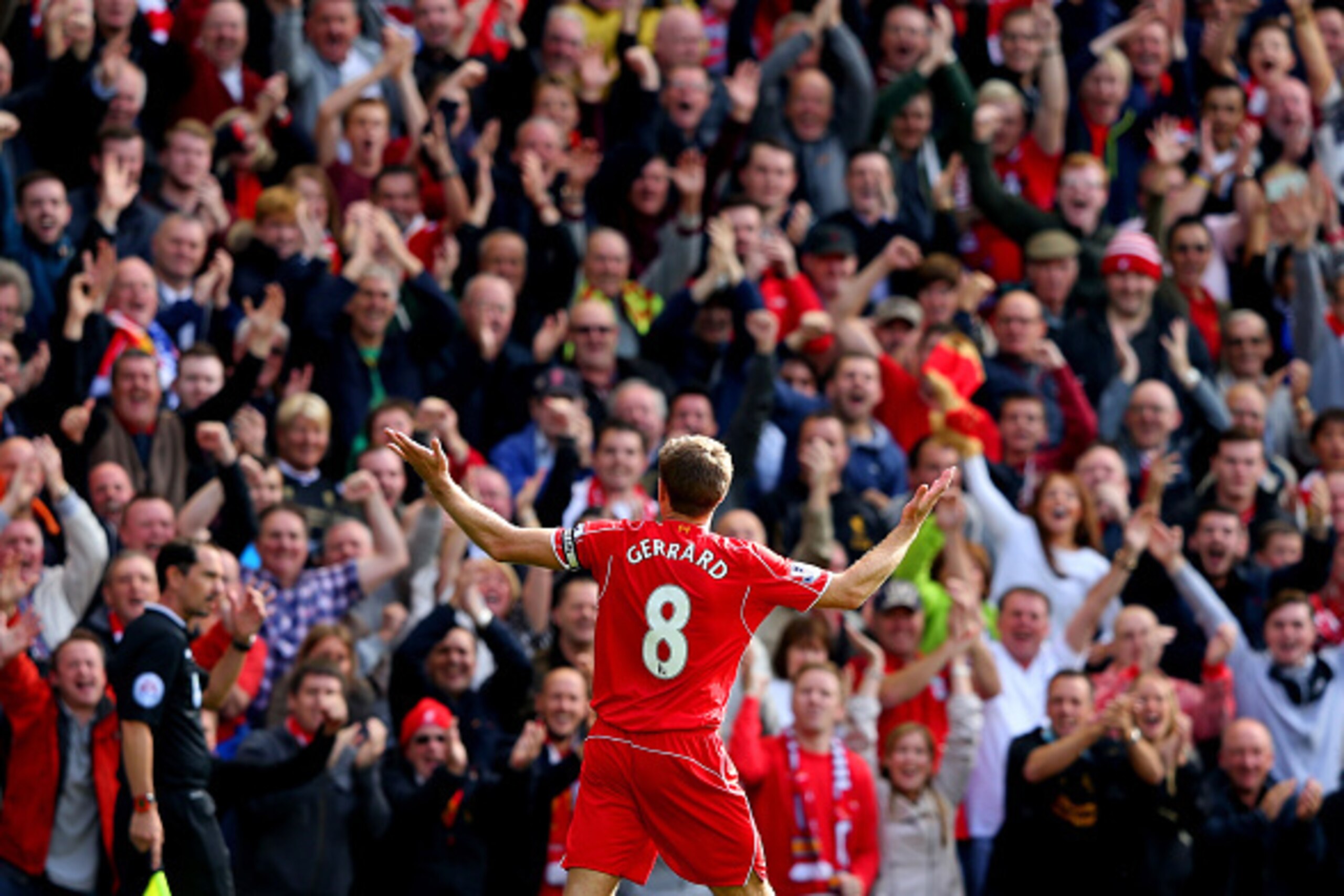 LIVERPOOL, ENGLAND - SEPTEMBER 27:  Steven Gerrard #8 of Liverpool infront of the home fans after scoring the opening goal from a free kick during the Barclays Premier League match between Liverpool and Everton at Anfield on September 27, 2014 in Liverpoo