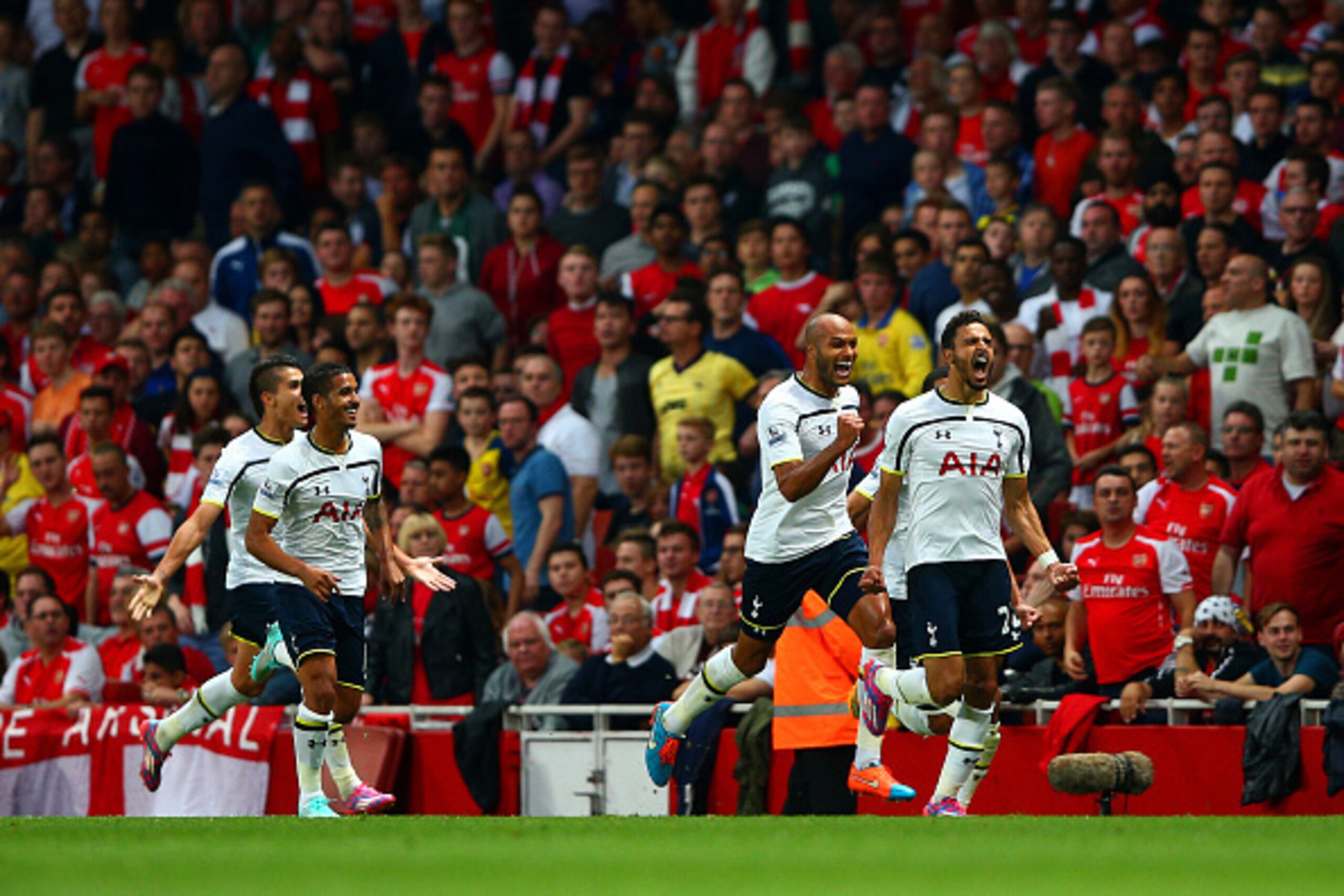 LONDON, ENGLAND - SEPTEMBER 27:  Nacer Chadli of Spurs celebrates with team-mates after scoring the opening goal during the Barclays Premier League match between Arsenal and Tottenham Hotspur at Emirates Stadium on September 27, 2014 in London, England.  
