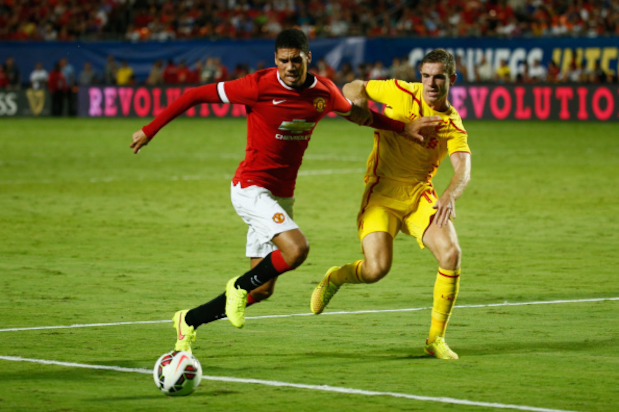 MIAMI GARDENS, FL - AUGUST 04:  (L) Chris Smalling #12 of Manchester United is challenged by (R) Jordan Henderson #14 of Liverpool in the Guinness International Champions Cup 2014 Final at Sun Life Stadium on August 4, 2014 in Miami Gardens, Florida.  (Ph