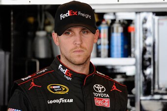 DOVER, DE - SEPTEMBER 27:  Denny Hamlin, driver of the #11 FedEx Freight Toyota, stands in the garage area during practice for the NASCAR Sprint Cup Series AAA 400 at Dover International Speedway on September 27, 2014 in Dover, Delaware.  (Photo by Jared 