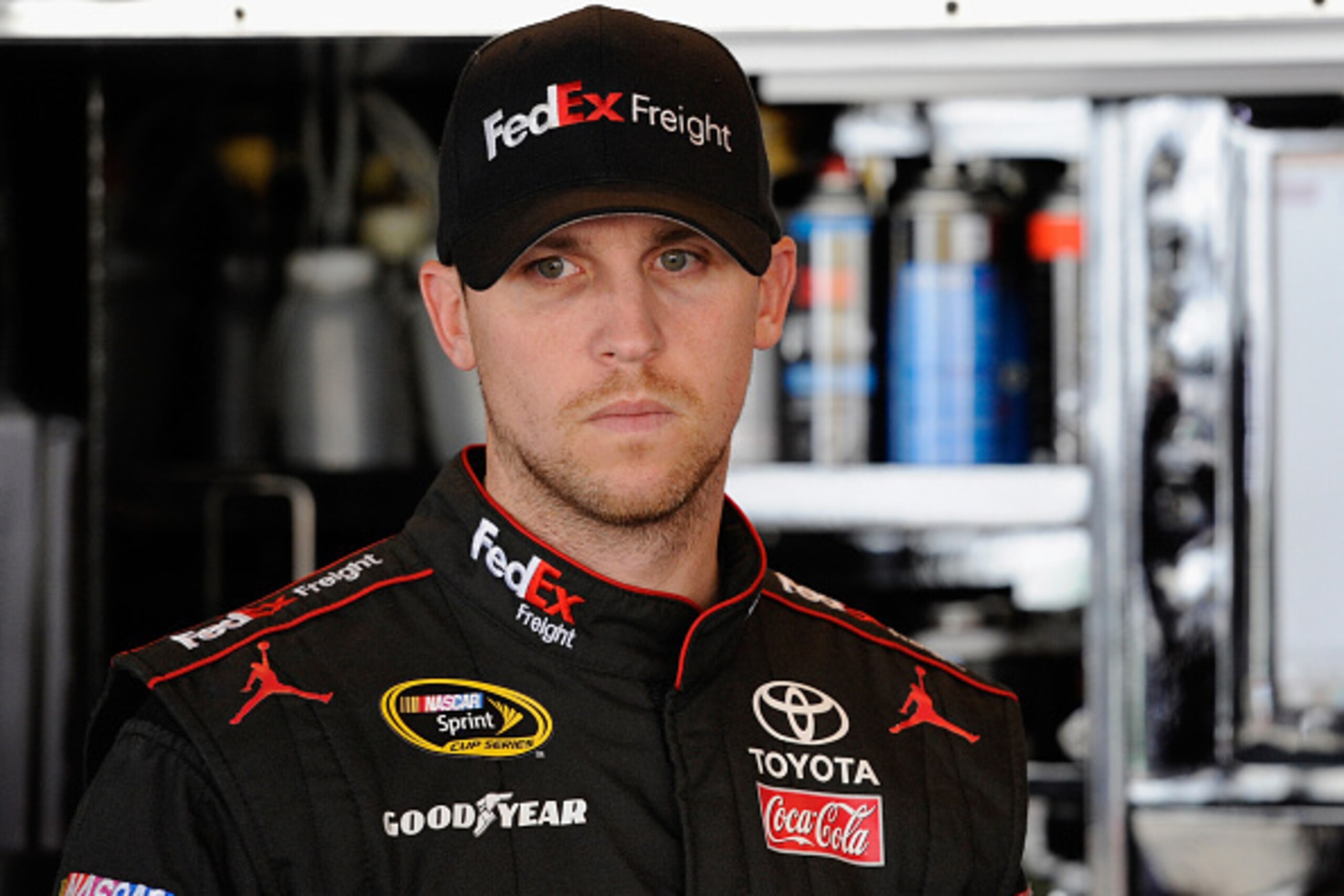 DOVER, DE - SEPTEMBER 27:  Denny Hamlin, driver of the #11 FedEx Freight Toyota, stands in the garage area during practice for the NASCAR Sprint Cup Series AAA 400 at Dover International Speedway on September 27, 2014 in Dover, Delaware.  (Photo by Jared 