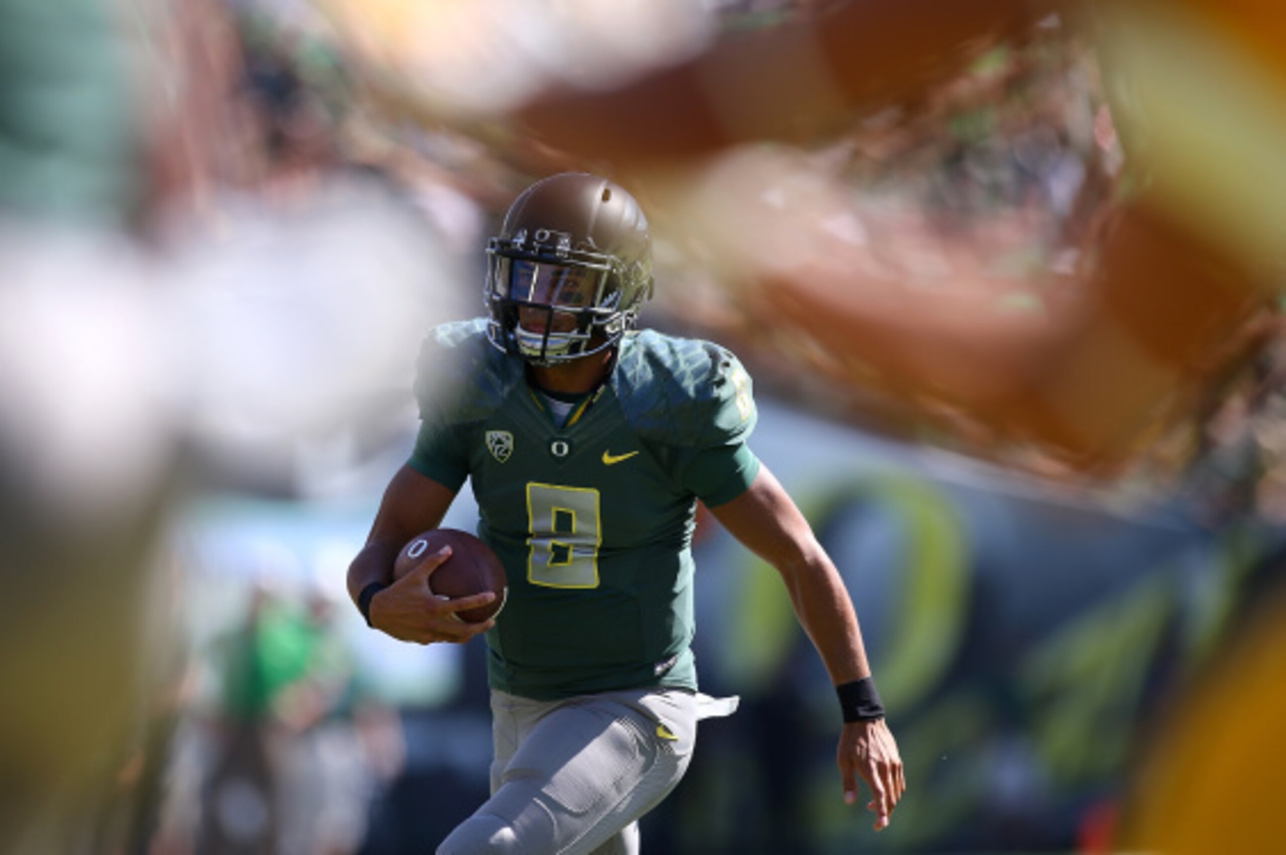 EUGENE, OR - SEPTEMBER 13:  Quarterback Marcus Mariota #8 of the Oregon Ducks runs with the ball against the Wyoming Coyboys at Autzen Stadium on September 13, 2014 in Eugene, Oregon.  (Photo by Jonathan Ferrey/Getty Images)
