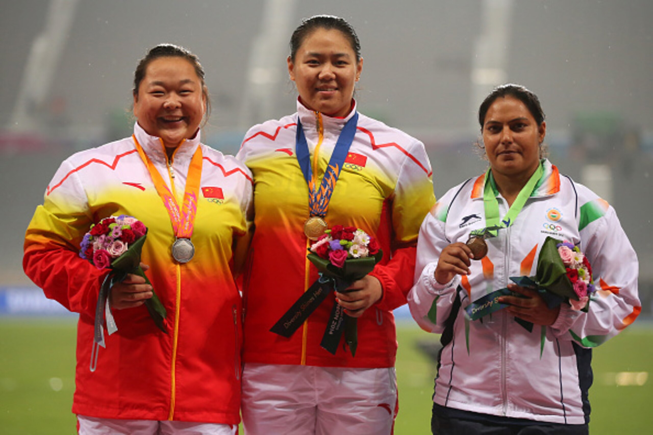 INCHEON, SOUTH KOREA - SEPTEMBER 28:  (L to R) Silver medalist Wang Zheng of China, gold medalist Zhang Wenxiu of China and bronze medalist Bala Manju of India celebrate on the podium during the victory ceremony for the Women's Hammer Throw during day nin