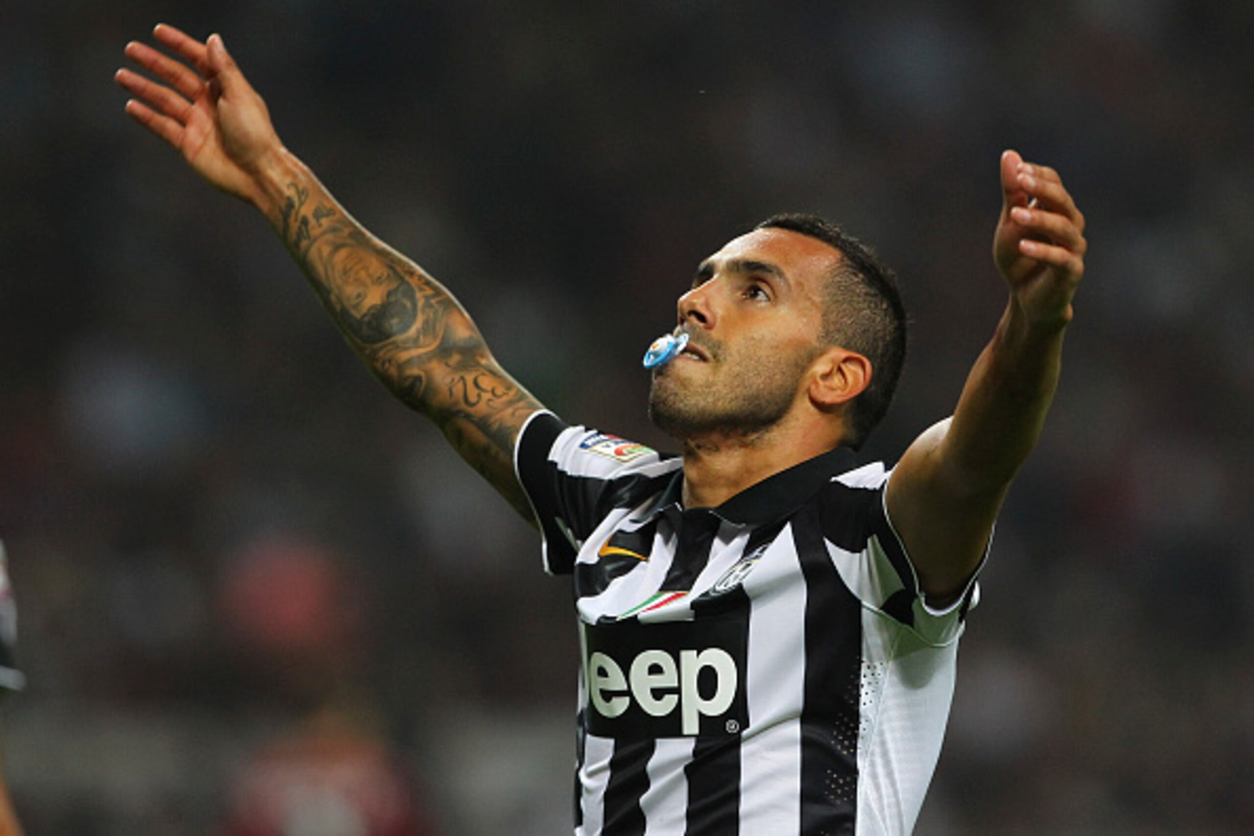 MILAN, ITALY - SEPTEMBER 20:  Carlos Tevez of Juventus FC celebrates after scoring the opening goal during the Serie A match between AC Milan and Juventus FC at Stadio Giuseppe Meazza on September 20, 2014 in Milan, Italy.  (Photo by Marco Luzzani/Getty I