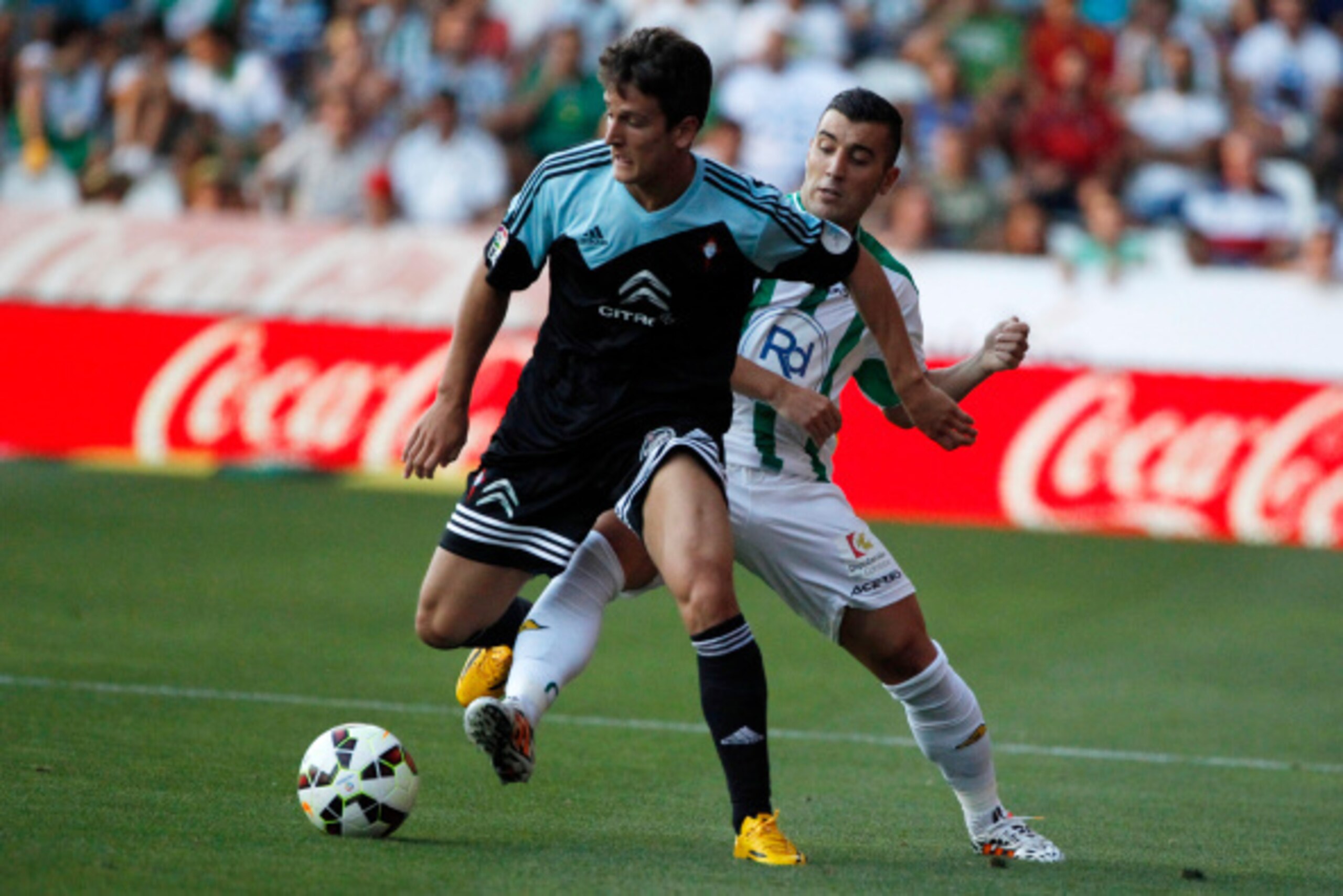 CORDOBA, SPAIN - AUGUST 30:  Nemanja Radoja of RC Celta de Vigo (L) duels for the ball with Aritz Lopez Garai of Cordoba CF during the La liga match between Cordoba CF and RC Celta de Vigo at El Arcangel studium on August 30, 2014 in Cordoba, Spain. (Phot