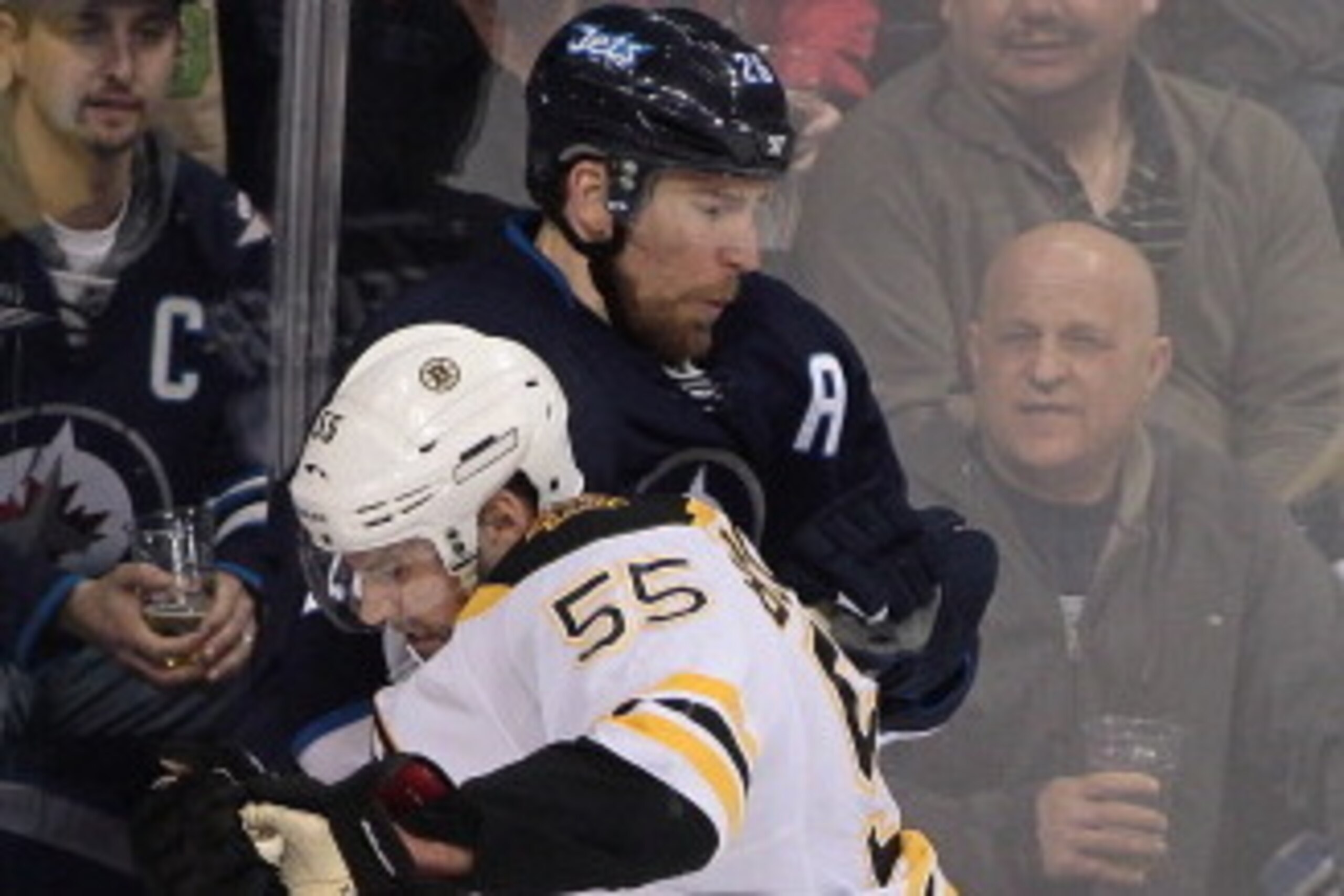 WINNIPEG, MB - APRIL 10: Johnny Boychuk #55 of the Boston Bruins takes Blake Wheeler #26 of the Winnipeg Jets to the boards in first period action in an NHL game at the MTS Centre on April 10, 2014 in Winnipeg, Manitoba, Canada. (Photo by Marianne Helm/ WINNIPEG, MB - APRIL 10: Johnny Boychuk #55 of the Boston Bruins takes Blake Wheeler #26 of the Winnipeg Jets to the boards in first period action in an NHL game at the MTS Centre on April 10, 2014 in Winnipeg, Manitoba, Canada. (Photo by Marianne Helm/
