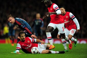 LONDON, ENGLAND - FEBRUARY 19:  Mario Goetze of Bayern Muenchen clashes with Mathieu Flamini and Bacary Sagna of Arsenal during the UEFA Champions League Round of 16 first leg match between Arsenal and FC Bayern Muenchen at Emirates Stadium on February 19