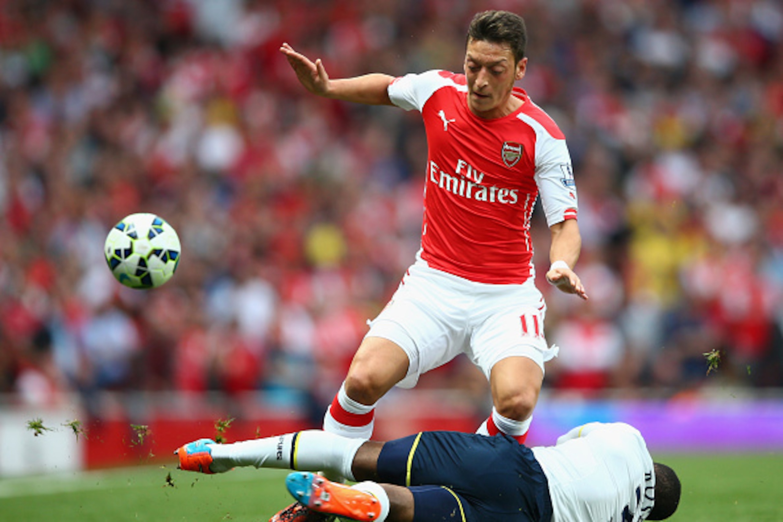 LONDON, ENGLAND - SEPTEMBER 27:  Mesut Oezil of Arsenal in action against Danny Rose of Spurs during the Barclays Premier League match between Arsenal and Tottenham Hotspur at Emirates Stadium on September 27, 2014 in London, England.  (Photo by Paul Gilh