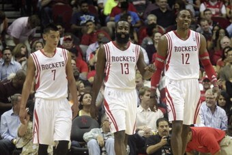 HOUSTON, TX - NOVEMBER 01:  Dwight Howard #12 of the Houston Rockets  along with Jeremy Lin #7 helps up James Harden #13 after he was foulded in the second quarter against the Dallas Mavericks at Toyota Center on November 1, 2013 in Houston, Texas. NOTE T