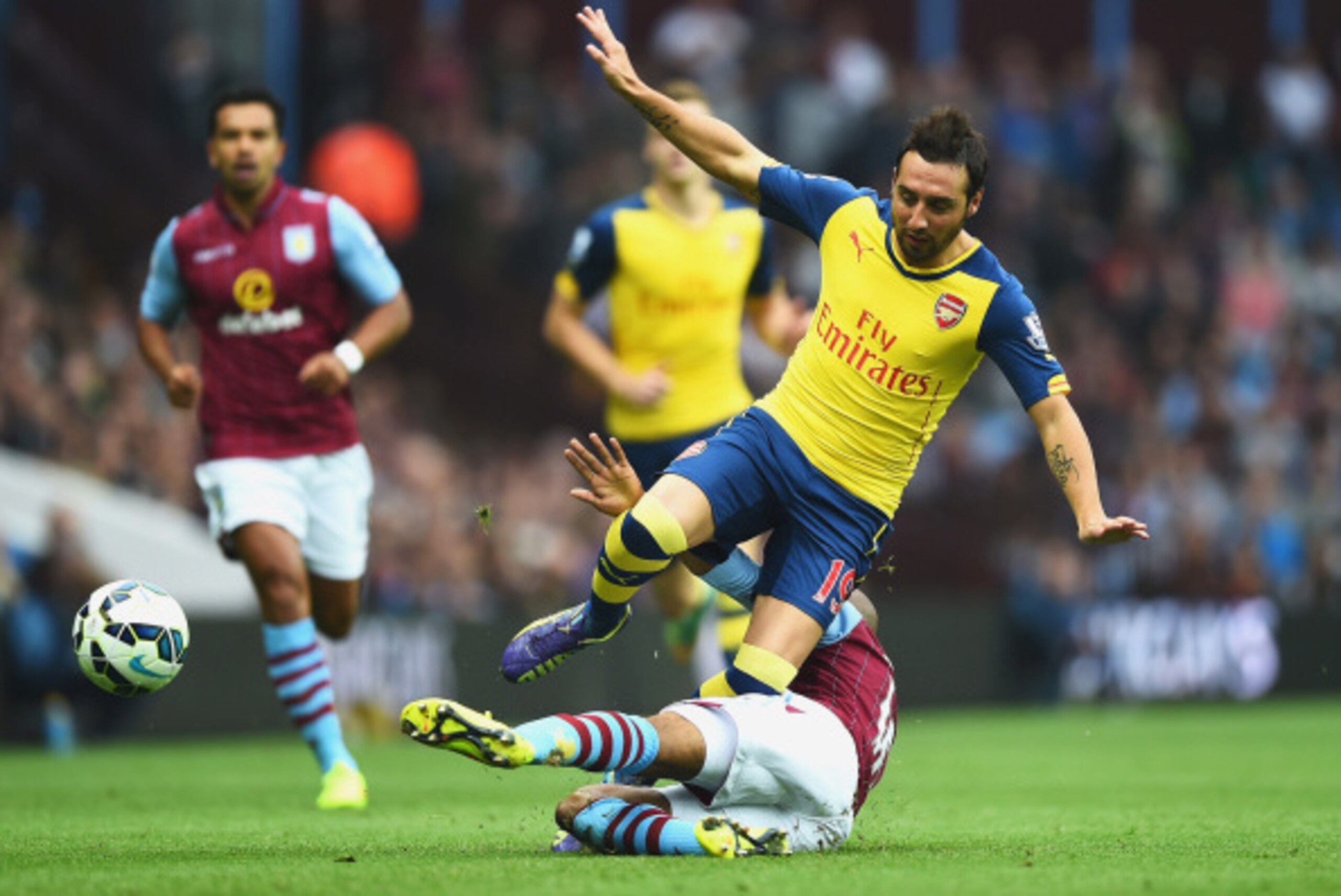 BIRMINGHAM, ENGLAND - SEPTEMBER 20: Santi Cazorla of Arsenal is challenged during the Barclays Premier League match between Aston Villa and Arsenal at Villa Park on September 20, 2014 in Birmingham, England.  (Photo by Laurence Griffiths/Getty Images)