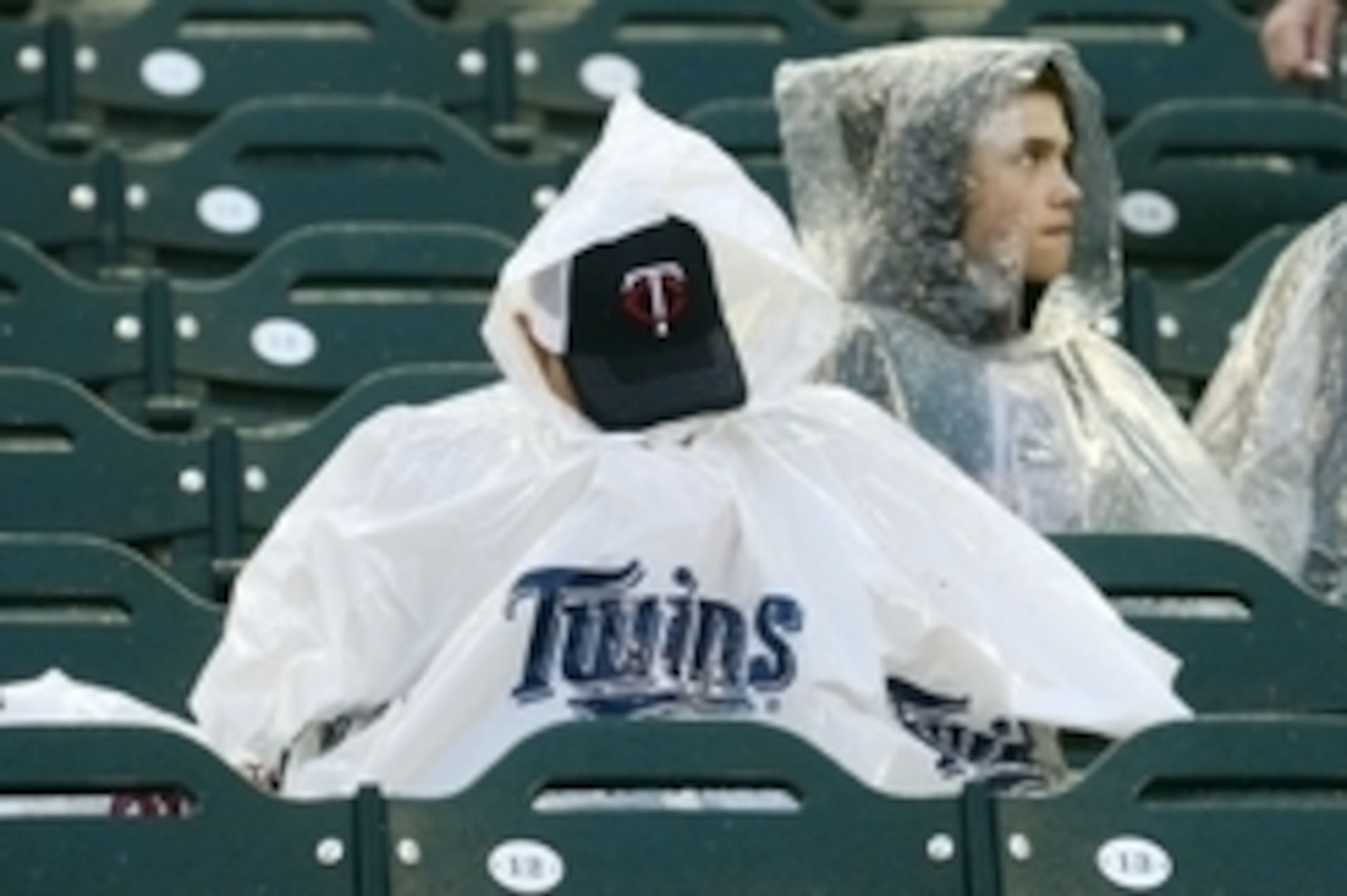 Jul 14, 2014; Minneapolis, MN, USA; A fan of the Minnesota Twins covers ducks his head inside a rain poncho as rain delays the start of the 2014 Home Run Derby the day before the MLB All Star Game at Target Field. Mandatory Credit: Jeff Curry-USA TODAY Sp
