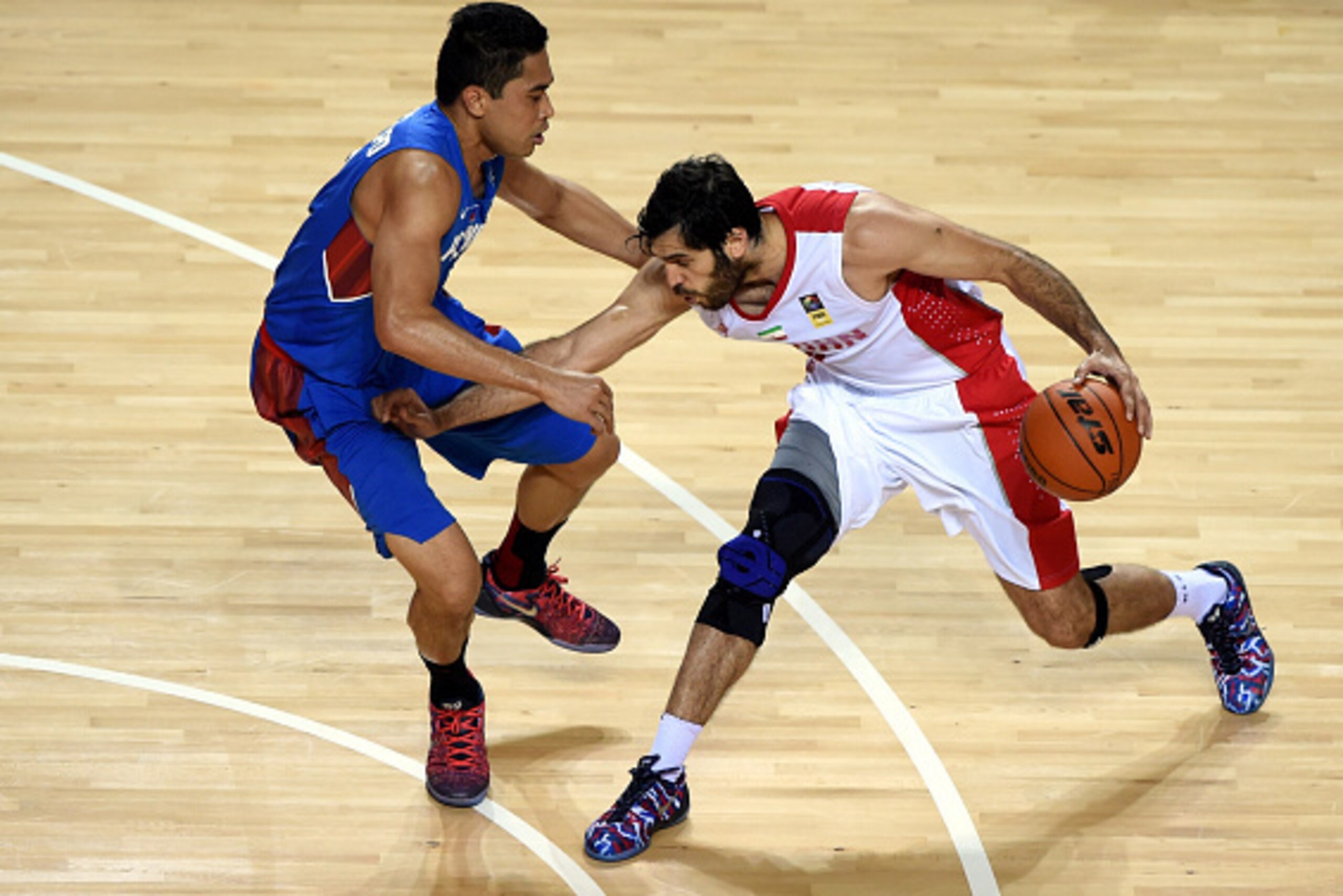 INCHEON, SOUTH KOREA - SEPTEMBER 25:  Ranidel de Ocampo of the Philippines challenges Mohammadsamad Nik Khahbahrami of Iran during the Basketball Mens Preliminary round match between Iran and the Philippines during day five of the 2014 Asian Games at Hwas