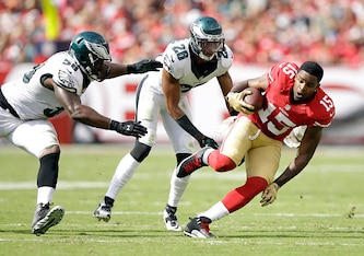 SANTA CLARA, CA - SEPTEMBER 28:  Michael Crabtree #15 of the San Francisco 49ers runs away from Trent Cole #58 and Cary Williams #26 of the Philadelphia Eagles after Williams pulled Crabree's helmet off in the second quarter of their game at Levi's Stadiu
