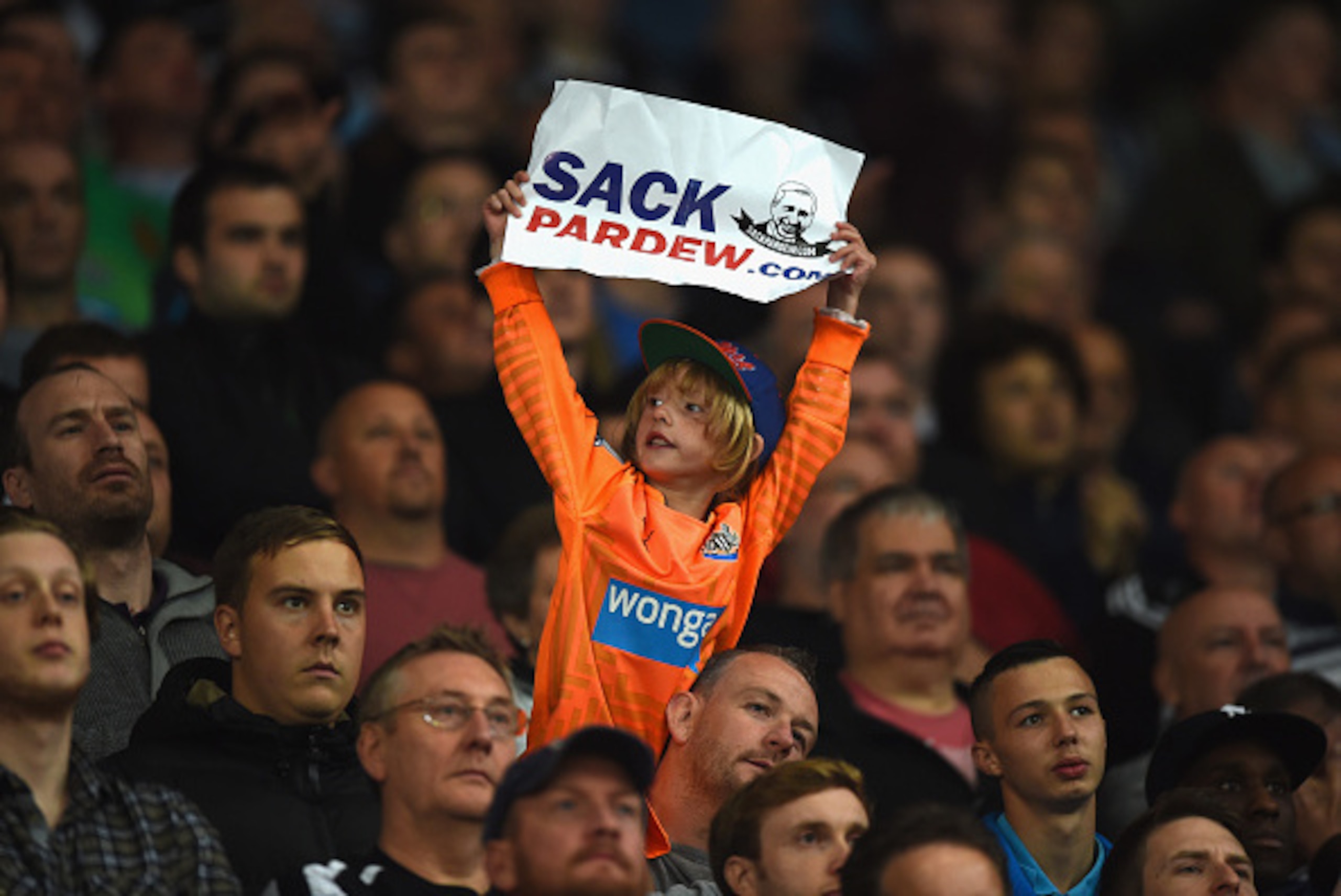 STOKE ON TRENT, ENGLAND - SEPTEMBER 29:  A young Newcastle fan holds up a sign calling for Alan Pardew, manager of Newcastle United, to be sacked during the Barclays Premier League match between Stoke City and Newcastle United at Britannia Stadium on Sept