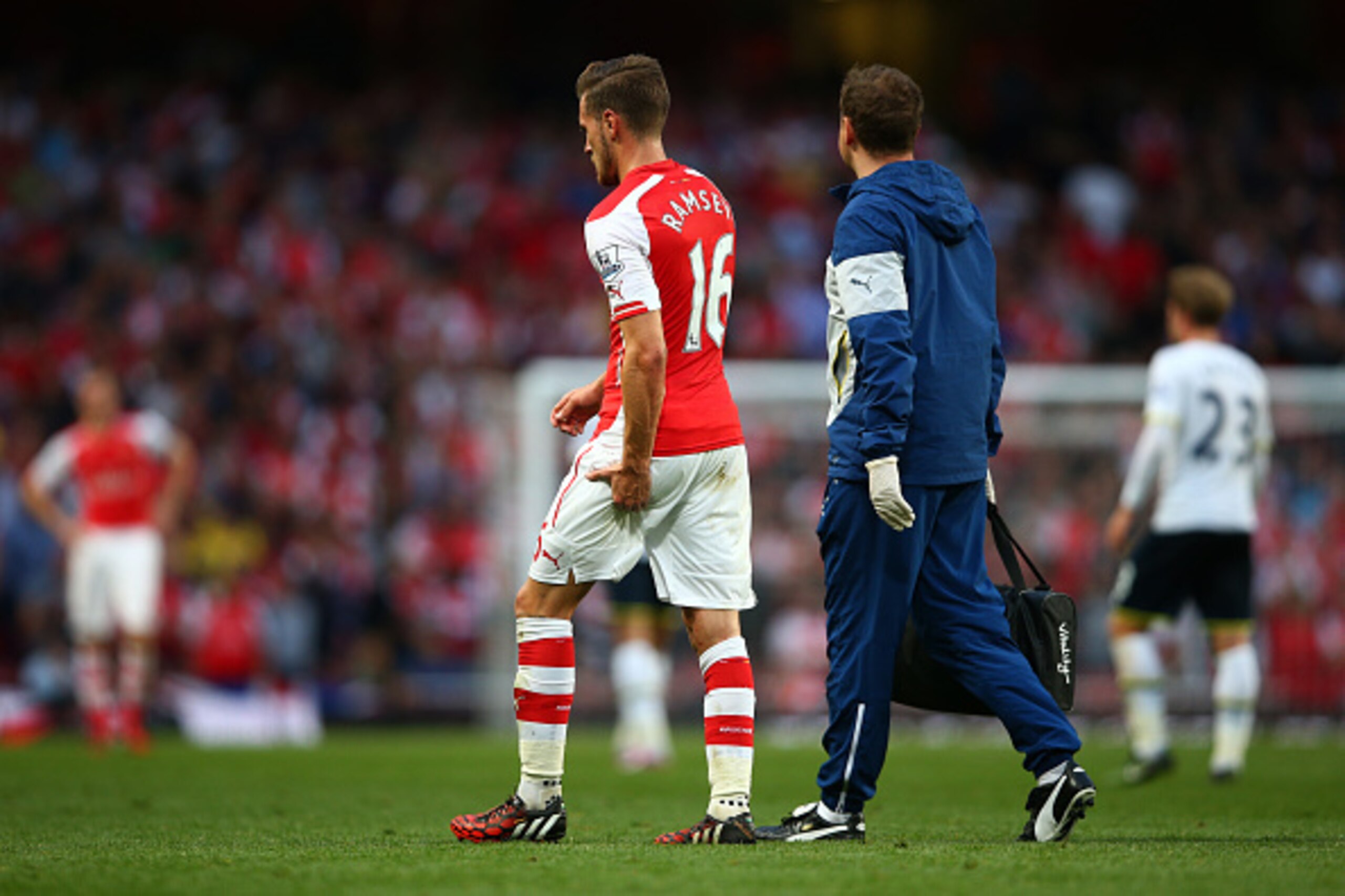 LONDON, ENGLAND - SEPTEMBER 27:  Aaron Ramsey of Arsenal holds his leg as he walks off the pitch after picking up an injury during the Barclays Premier League match between Arsenal and Tottenham Hotspur at Emirates Stadium on September 27, 2014 in London,