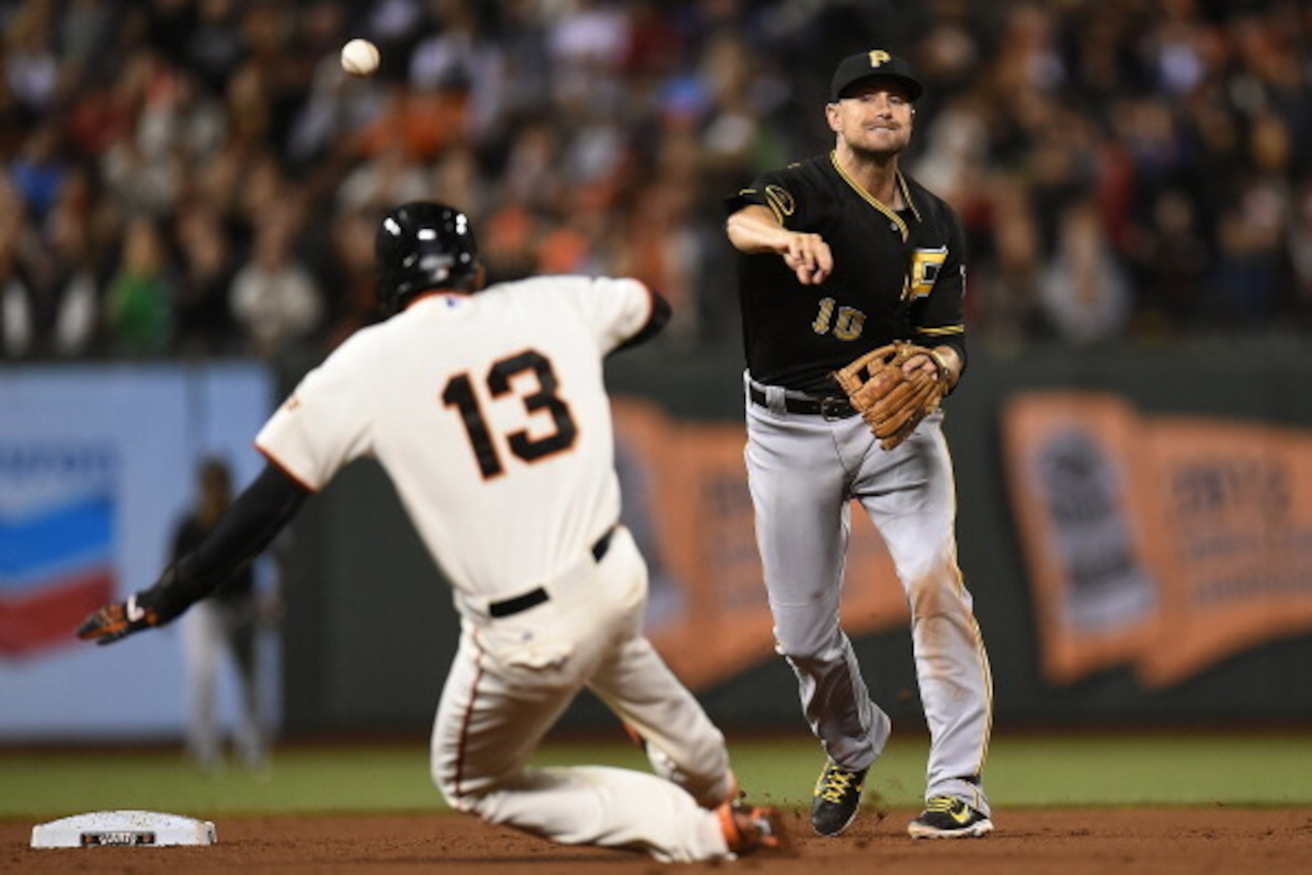 SAN FRANCISCO, CA - JULY 29:  Jordy Mercer #10 of the Pittsburgh Pirates completes the double-play over the top of Joaquin Arias #13 of the San Francisco Giants in the bottom of the eighth inning at AT&T Park on July 29, 2014 in San Francisco, California.