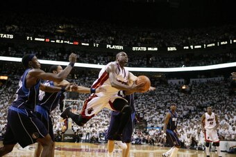 MIAMI - JUNE 18:  Dwyane Wade #3 of the Miami Heat gets fouled on his way to the basket against the Dallas Mavericks with 1.9 seconds remaining in overtime during Game Five of the 2006 NBA Finals June 18, 2006 at American Airlines Arena in Miami, Florida.