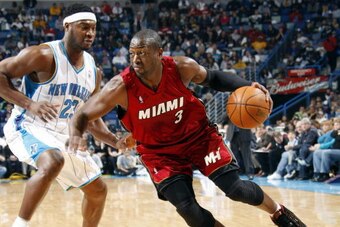 NEW ORLEANS - DECEMBER 30:  Dwyane Wade #3 of the Miami Heat drives past Devin Brown #23 of the New Orleans Hornets on December 30, 2009 at the New Orleans Arena in New Orleans, Louisiana. NOTE TO USER: User expressly acknowledges and agrees that, by down