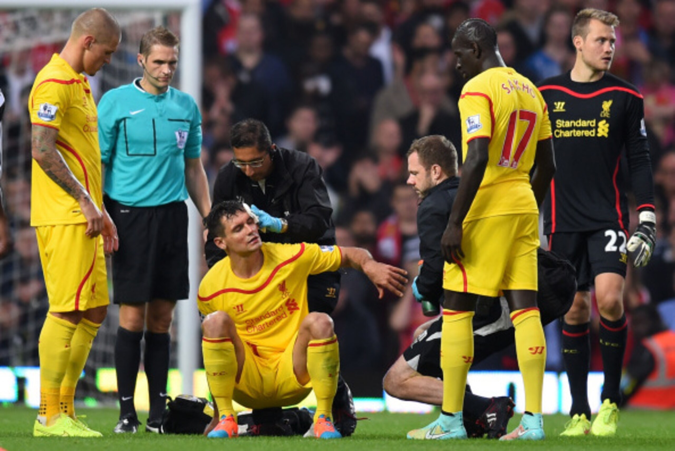 LONDON, ENGLAND - SEPTEMBER 20:  Dejan Lovren of Liverpool receives treatment following a clash of heads during the Barclays Premier League match between West Ham United and Liverpool at Boleyn Ground on September 20, 2014 in London, England.  (Photo by M