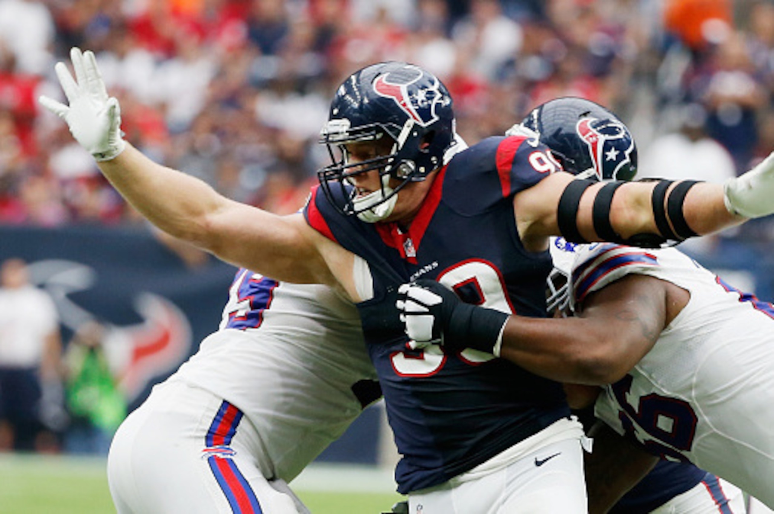 HOUSTON, TX - SEPTEMBER 28:  J.J. Watt #99 of the Houston Texans fisghts off two blockers during the third quarter of their game against the Buffalo Bills at NRG Stadium on September 28, 2014 in Houston, Texas.  (Photo by Scott Halleran/Getty Images)
