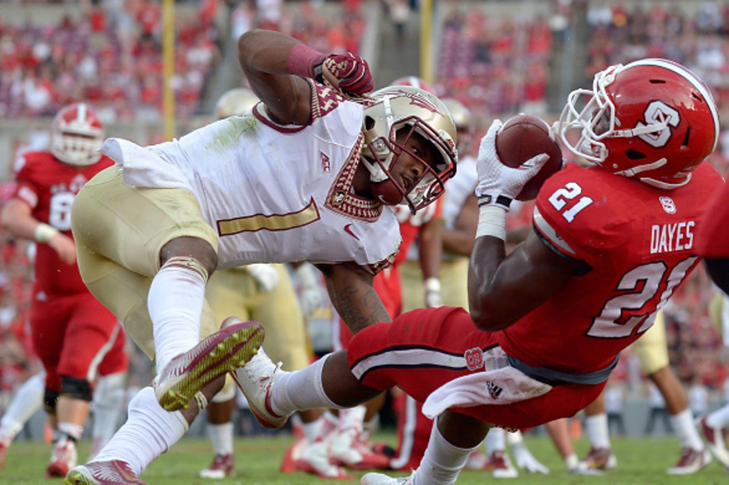 RALEIGH, NC - SEPTEMBER 27:  Matt Dayes #21 of the North Carolina State Wolfpack makes a touchdown catch against defender Tyler Hunter #1 of the Florida State Seminoles during their game at Carter-Finley Stadium on September 27, 2014 in Raleigh, North Car