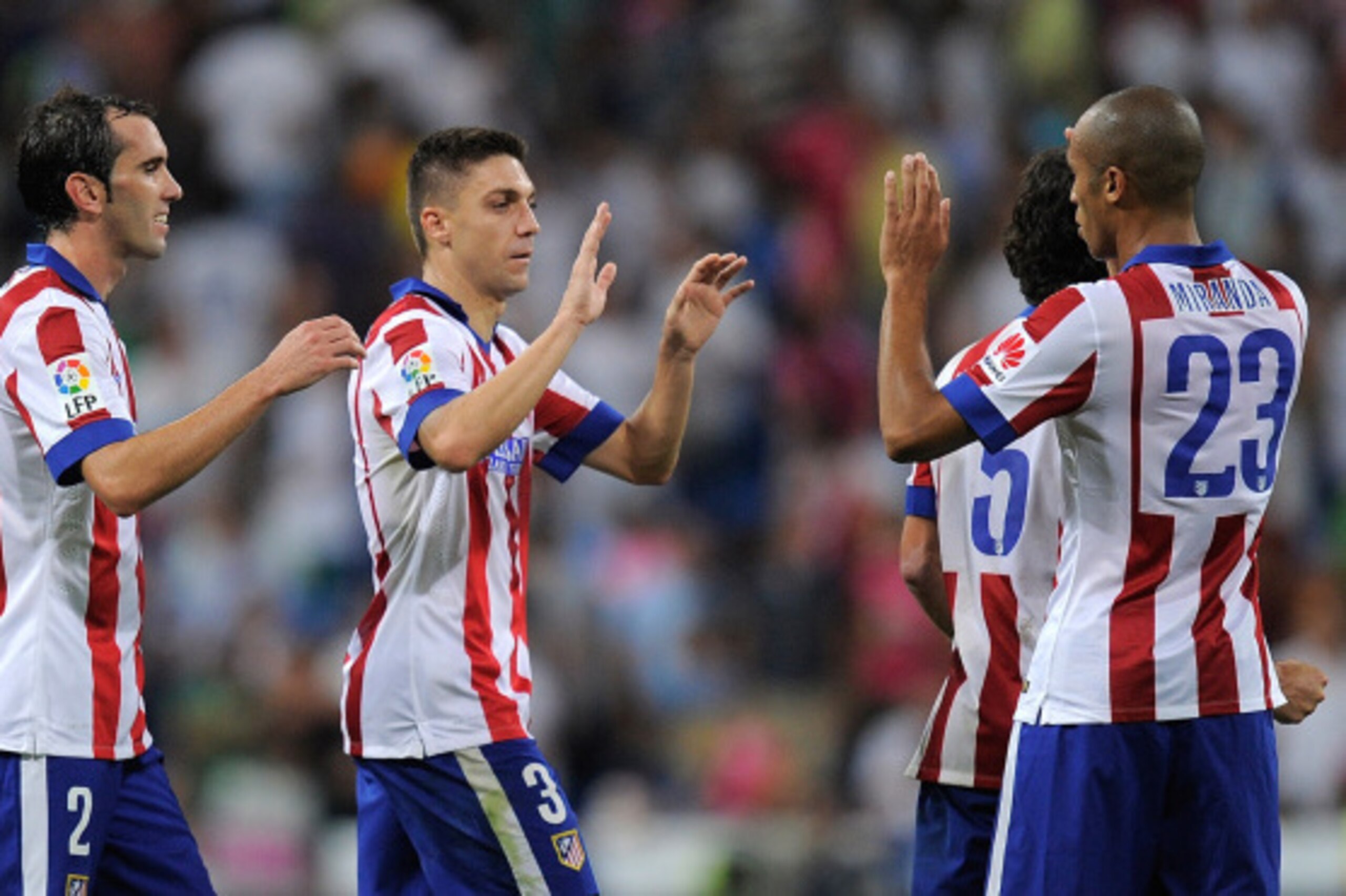 MADRID, SPAIN - SEPTEMBER 13: Diego Godin (#2) Guilherme Siqueira and Joao Miranda of Atletico de Madrid celebrate after beating Real Madrid 2-1 in the La Liga match between Real Madrid and Atletico de Madrid at Estadio Santiago Bernabeu on September 13, 