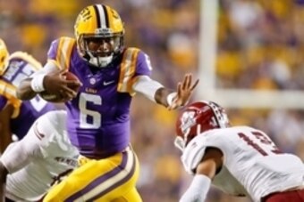 Sep 27, 2014; Baton Rouge, LA, USA; LSU Tigers quarterback Brandon Harris (6) stiff arms New Mexico State Aggies defensive back Adaryan Jones (19) during the second quarter of a game at Tiger Stadium. Mandatory Credit: Derick E. Hingle-USA TODAY Sports