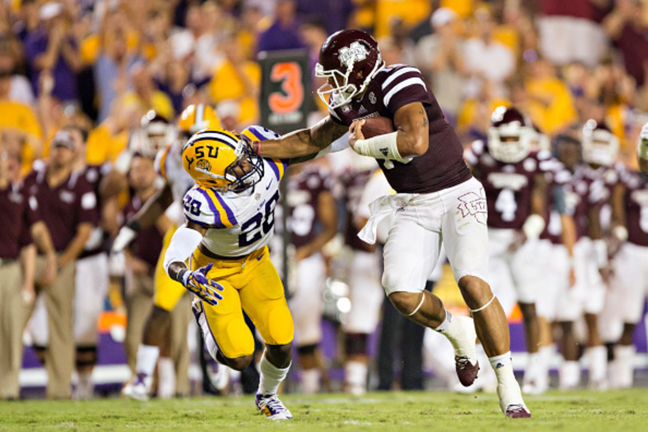 BATON ROUGE, LA - SEPTEMBER 20: Dak Prescott #15 of the Mississippi State Bulldogs stiff arms Jalen Mills #28 of the LSU Tigers at Tiger Stadium on September 20, 2014 in Baton Rouge, Louisiana. The Bulldogs defeated the Tigers 34-29. (Photo by Wesley Hi BATON ROUGE, LA - SEPTEMBER 20: Dak Prescott #15 of the Mississippi State Bulldogs stiff arms Jalen Mills #28 of the LSU Tigers at Tiger Stadium on September 20, 2014 in Baton Rouge, Louisiana. The Bulldogs defeated the Tigers 34-29. (Photo by Wesley Hi