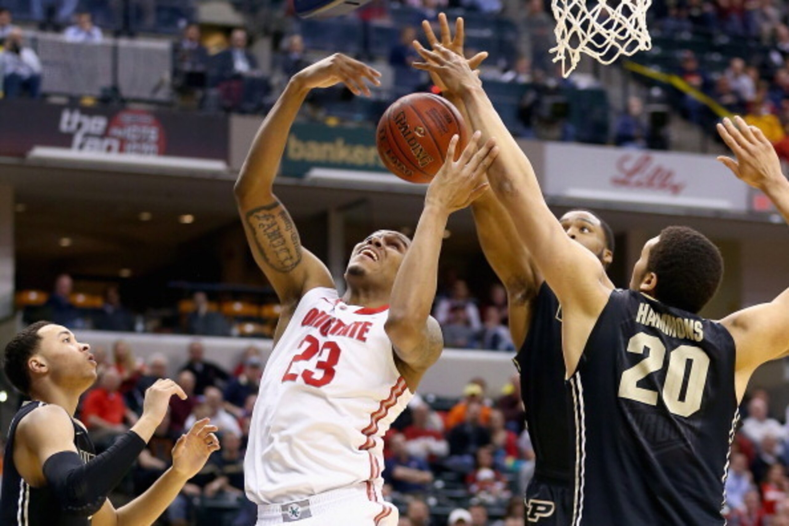 INDIANAPOLIS, IN - MARCH 13:  Amir Williams #23 of the Ohio State Buckeyes grabs a rebound in the game against the  Purdue Boilermakes during the first round of the Big Ten Basketball Tournament at Bankers Life Fieldhouse on March 13, 2014 in Indianapolis