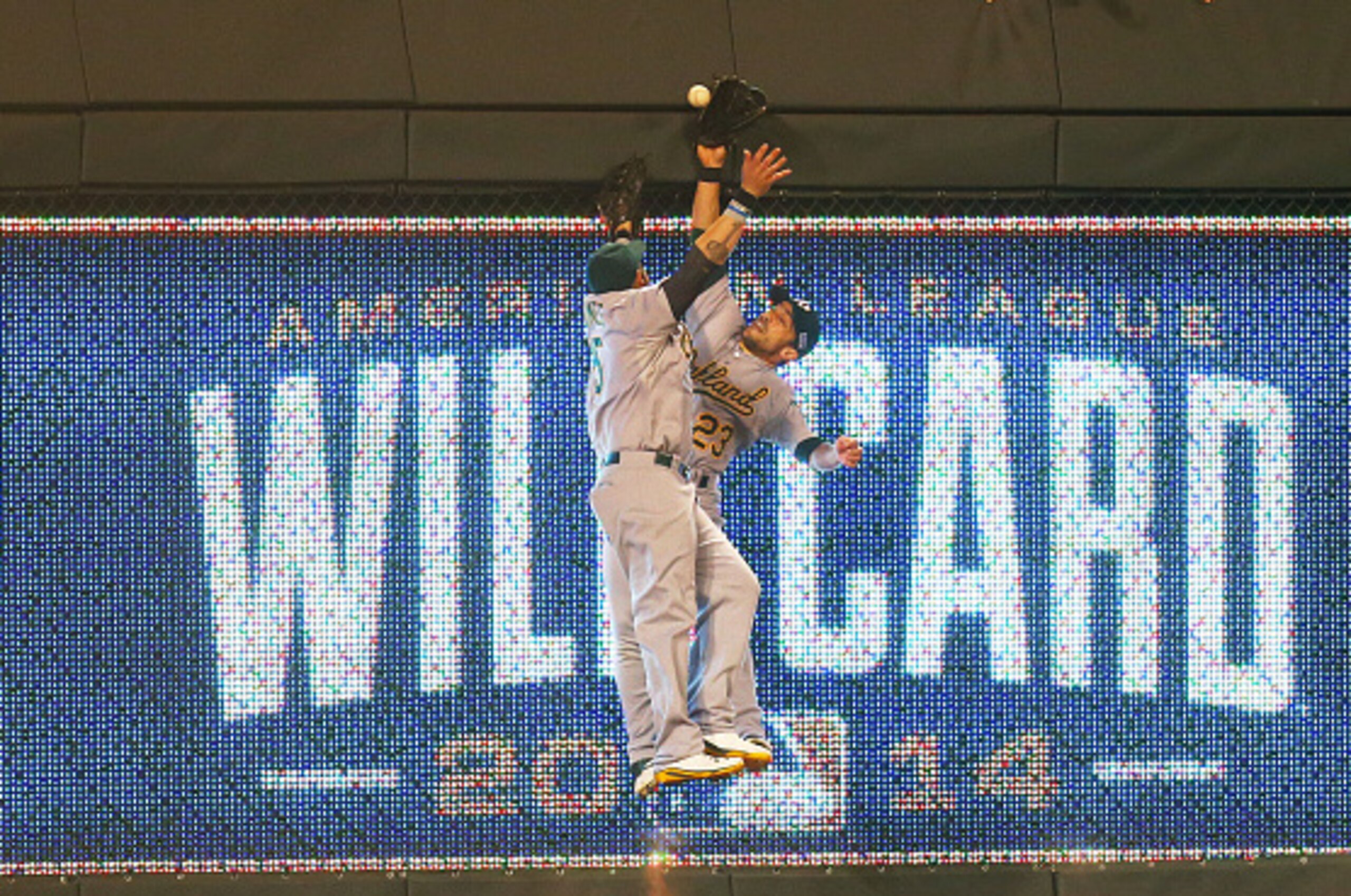 KANSAS CITY, MO - SEPTEMBER 30:  Jonny Gomes #15 and Sam Fuld #23 of the Oakland Athletics collide on a triple hit by Eric Hosmer #35 of the Kansas City Royals in the 12th inning during the American League Wild Card game at Kauffman Stadium on September 3