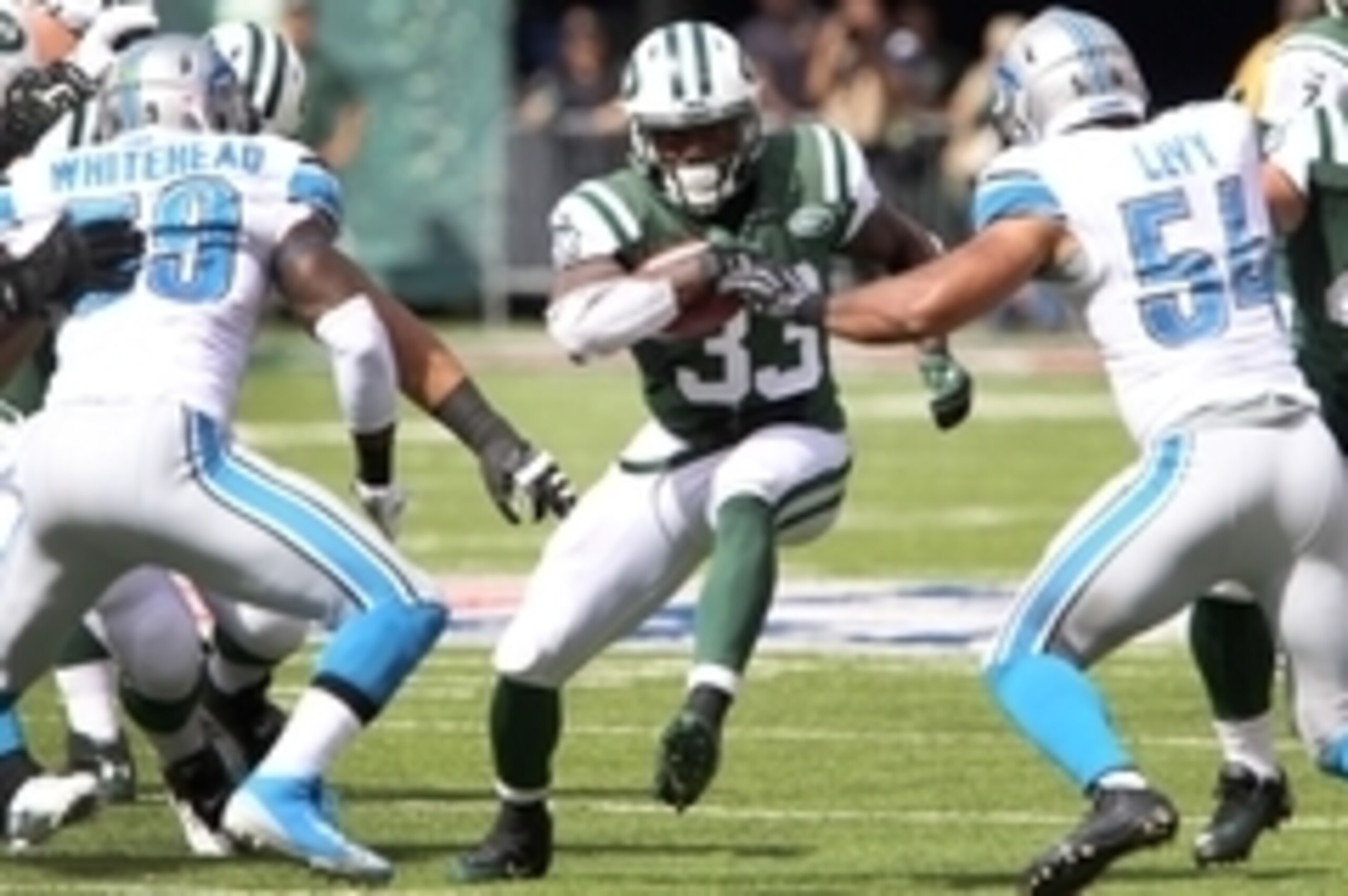 Sep 28, 2014; East Rutherford, NJ, USA;  New York Jets running back Chris Ivory (33) carries the ball as Detroit Lions outside linebacker Tahir Whitehead (59) and outside linebacker DeAndre Levy (54) defend in the first quarter at MetLife Stadium. Mandato