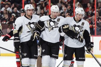 OTTAWA, ON - DECEMBER 23: Pascal Dupuis #9 of the Pittsburgh Penguins is helped off the ice by teammates Matt Niskanen #2 and Chris Kunitz #14 after he collided with a teammate during an NHL game against the Ottawa Senators at Canadian Tire Centre on Dece