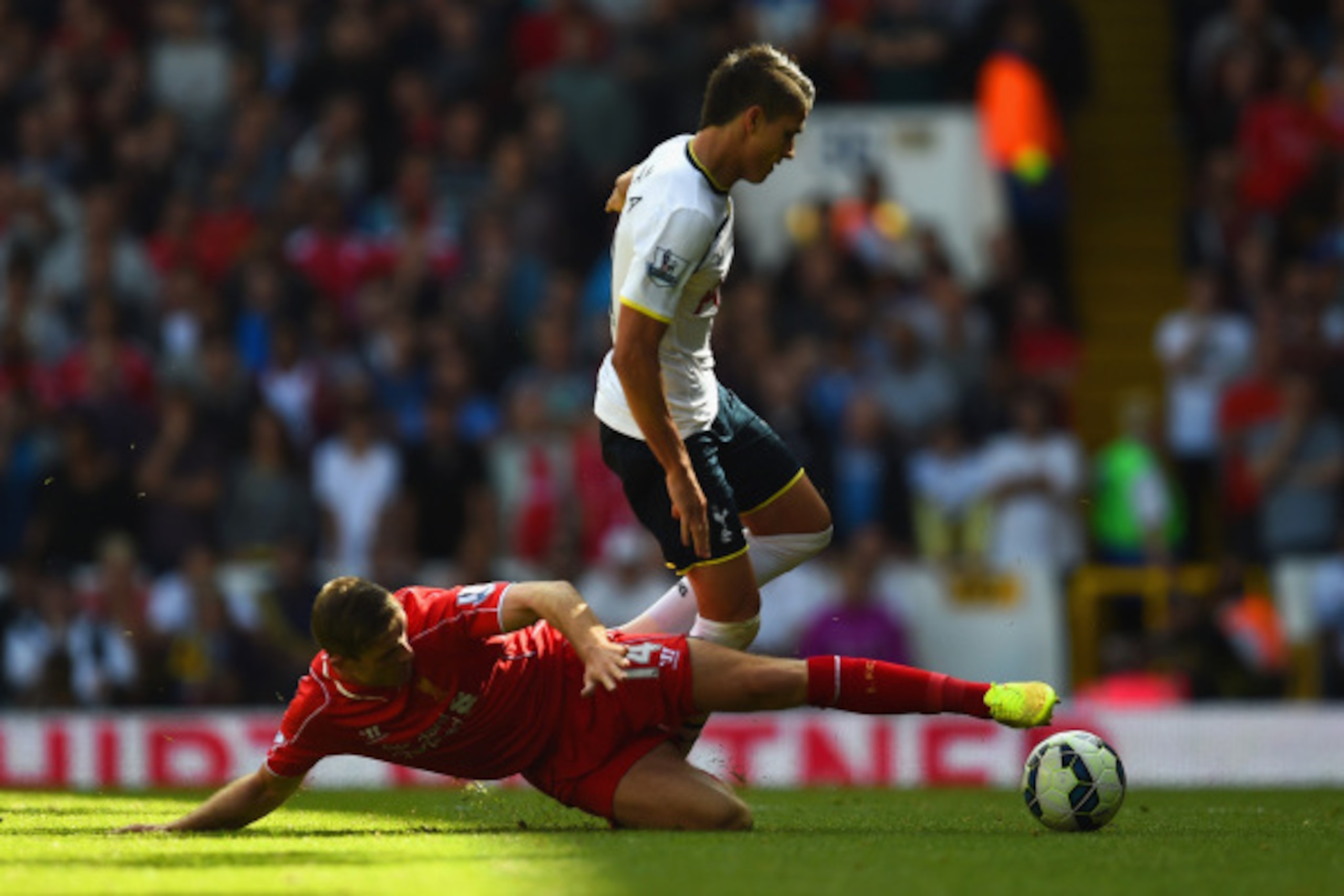 LONDON, ENGLAND - AUGUST 31:  Erik Lamela of Spurs leaps over the challenge from Jordan Henderson of Liverpool during the Barclays Premier League match between Tottenham Hotspur and Liverpool at White Hart Lane on August 31, 2014 in London, England.  (Pho